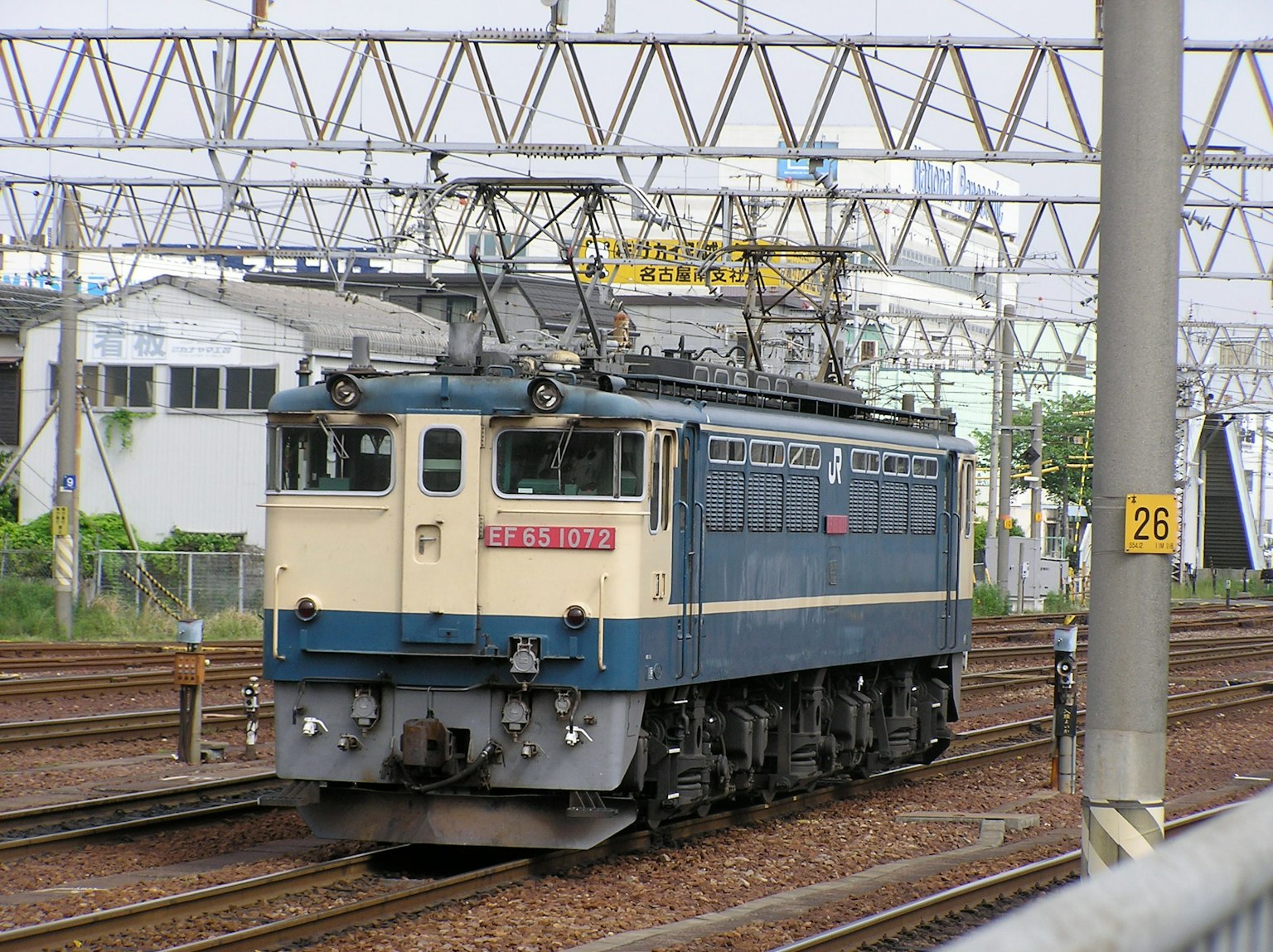 Locomotora eléctrica azul y blanca estacionada en una estación