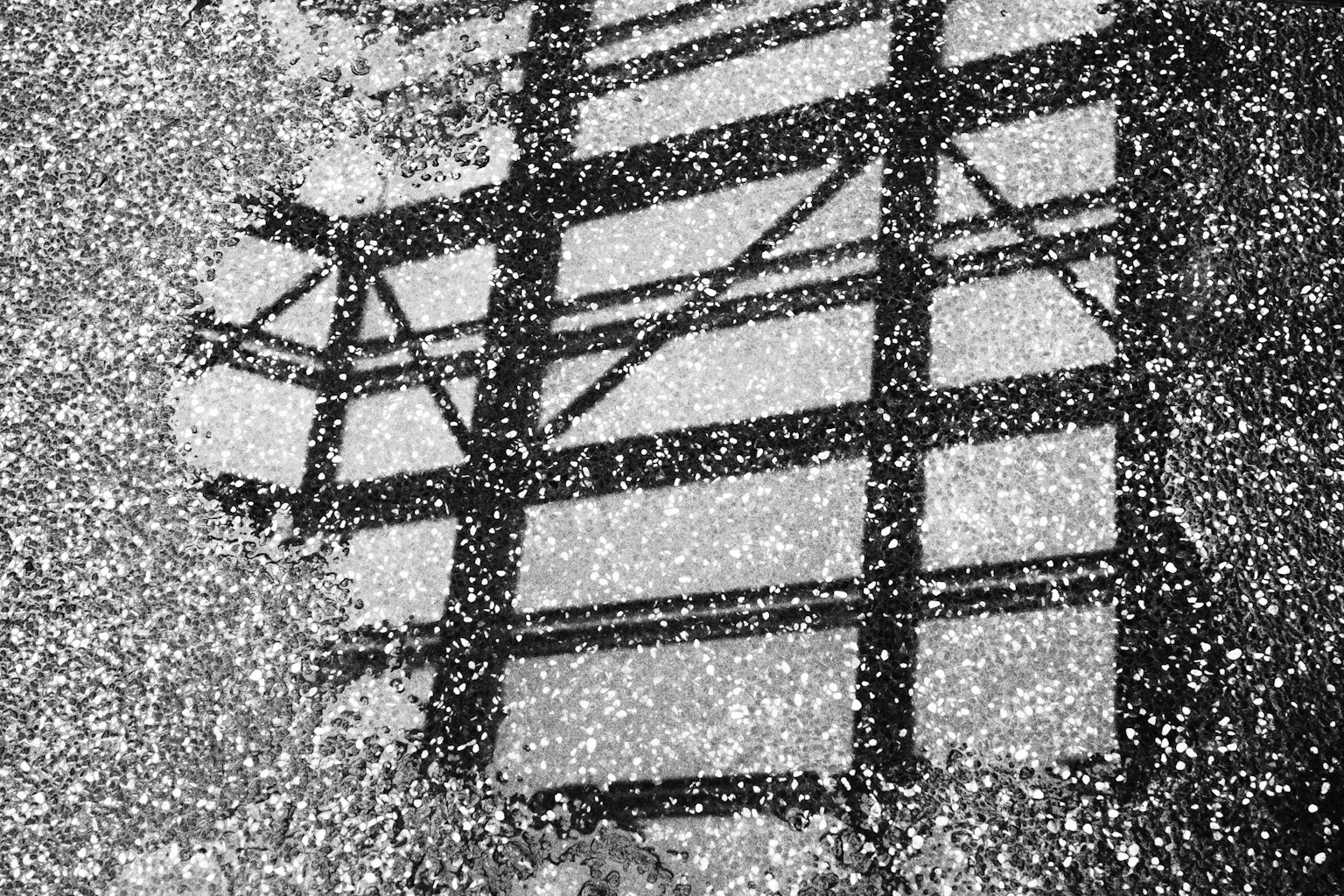 水面に映る建物の影と白い雪のような模様