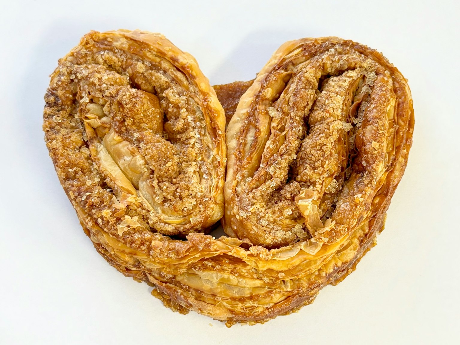 Primo piano di un dolce a forma di cuore con strati intricati e aspetto dorato