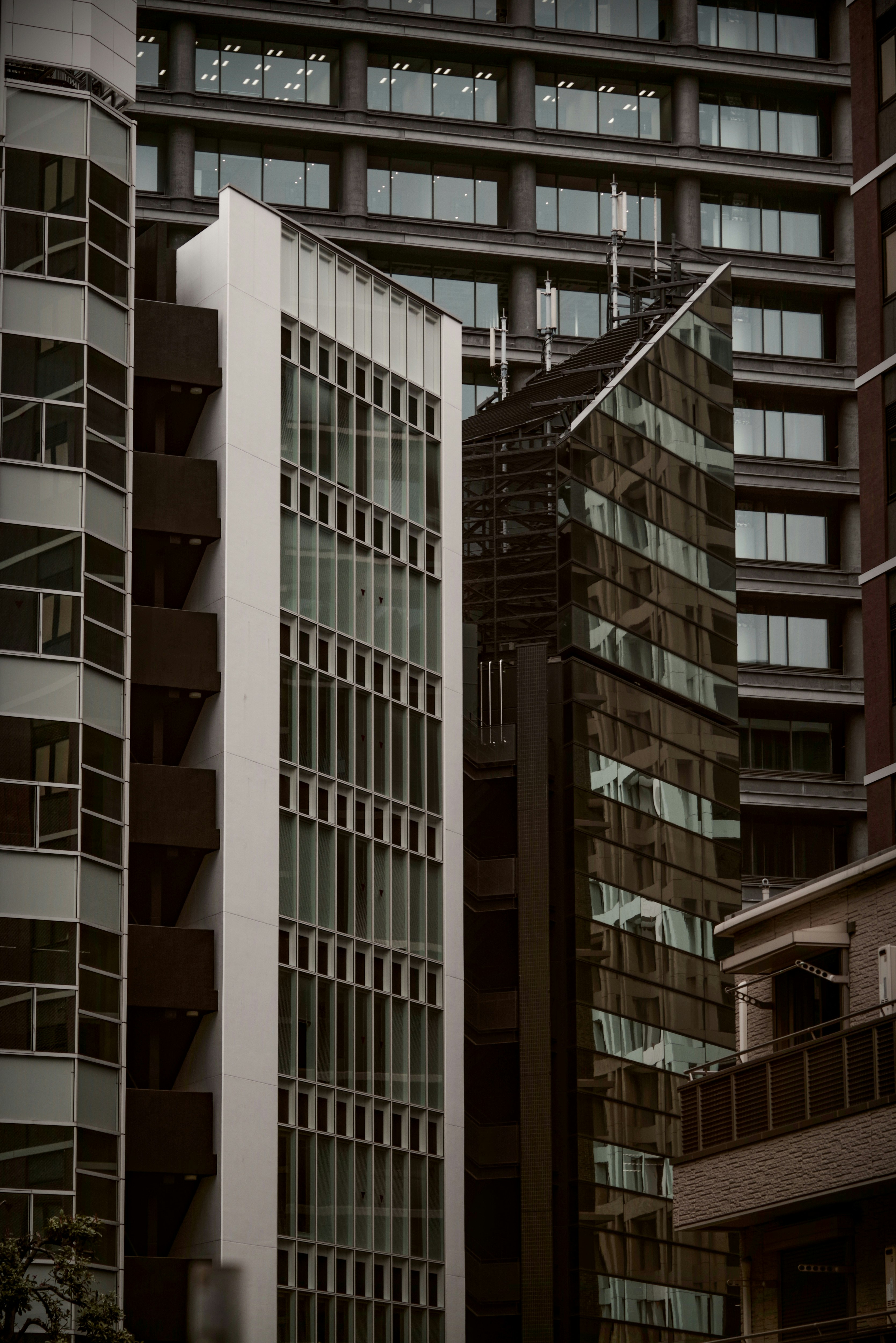 Exterior de un edificio con escalera exterior en un patio entre rascacielos en Tokio