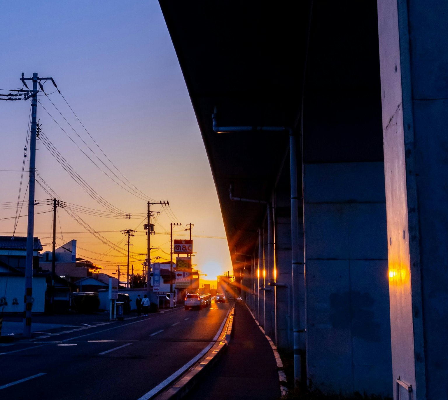 Sunset view along a road with silhouetted buildings