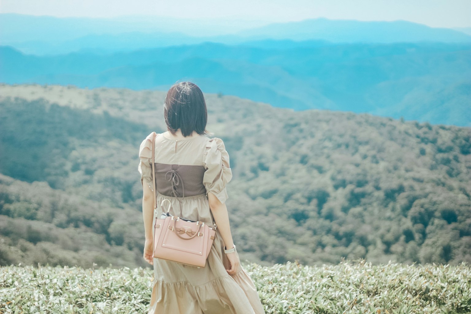 Una donna in piedi con un paesaggio montano sullo sfondo