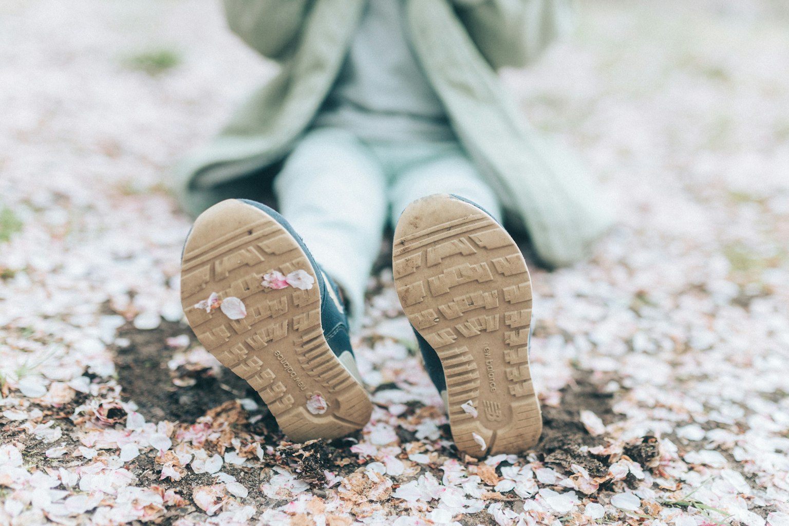 Imagen que muestra los pies de una persona descansando sobre pétalos de cerezo