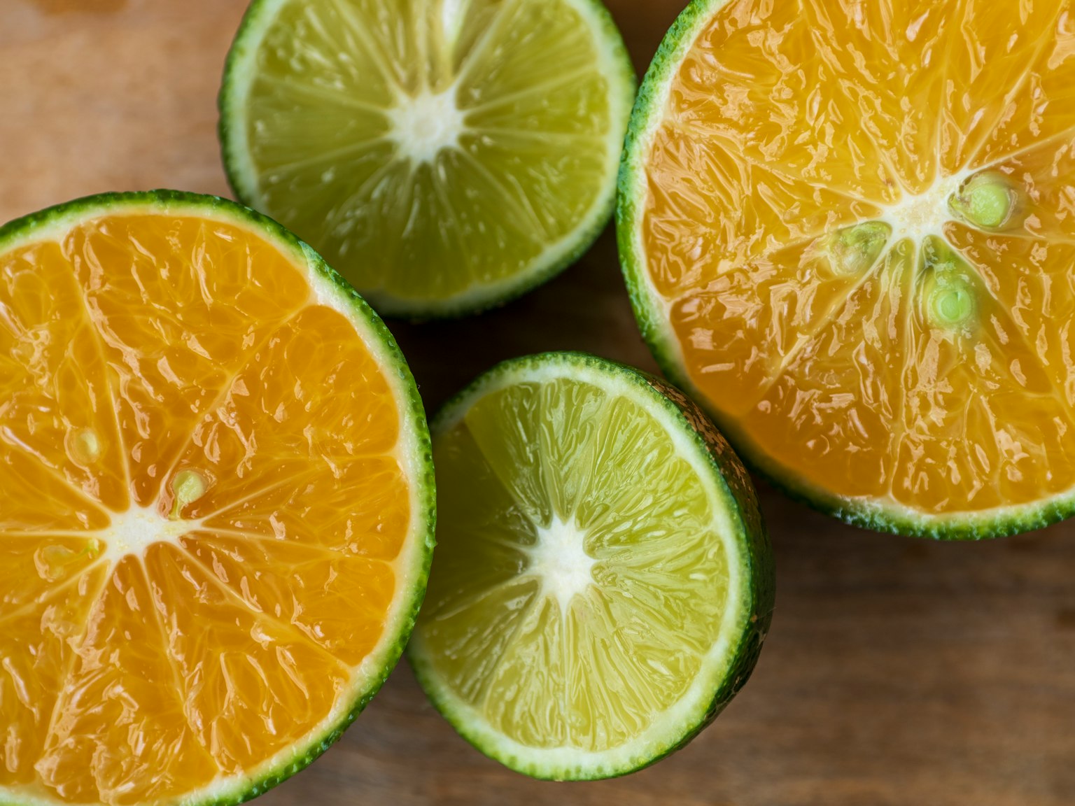 Rodajas de naranjas y limas dispuestas sobre una superficie de madera