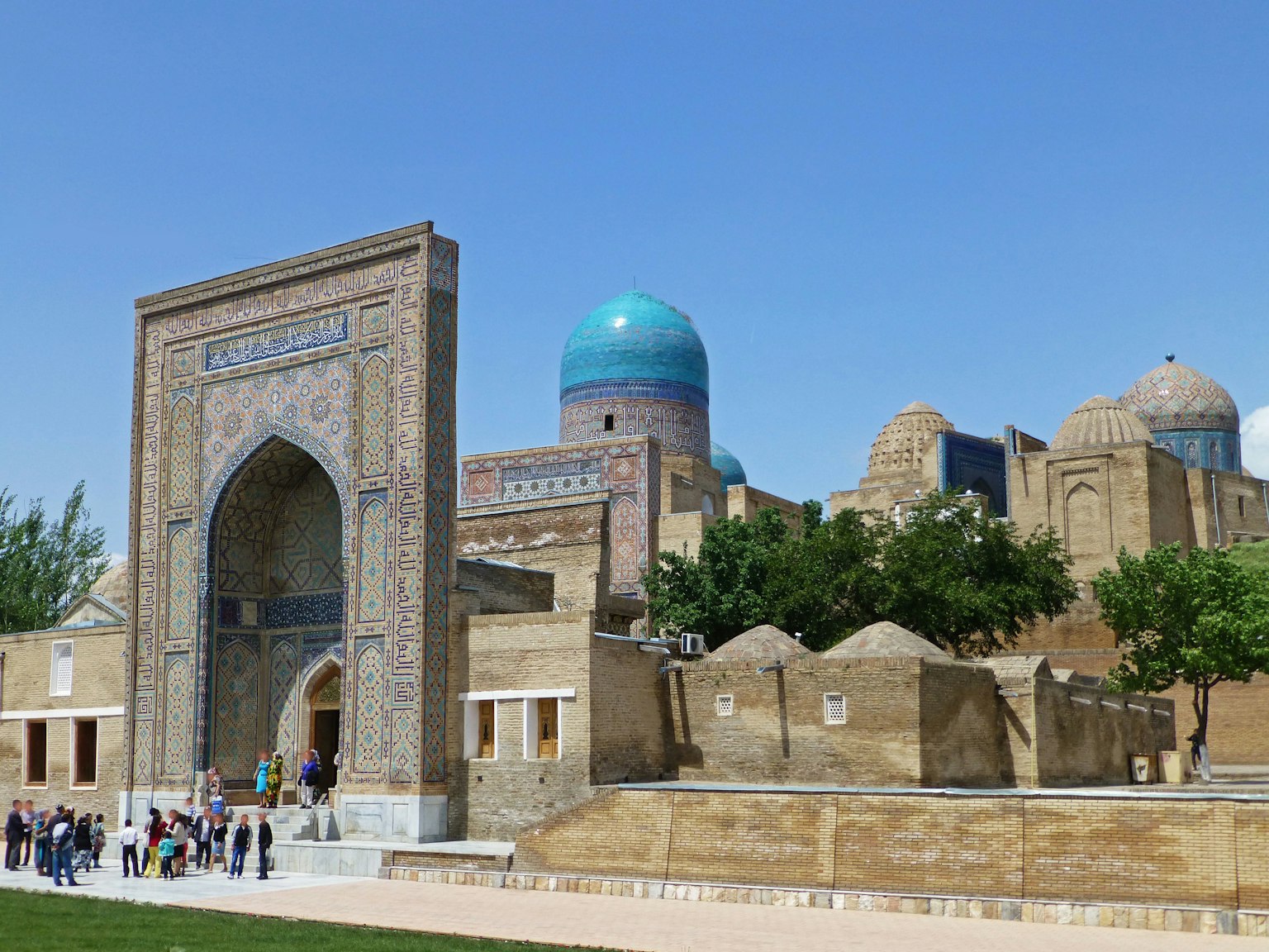 A scenic view of Uzbek architecture featuring a prominent blue dome mosque and historical buildings