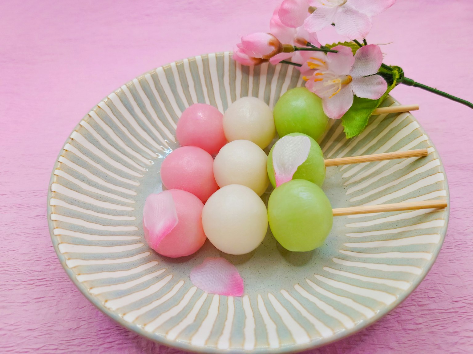Un piatto di dango colorato con fiori di ciliegio