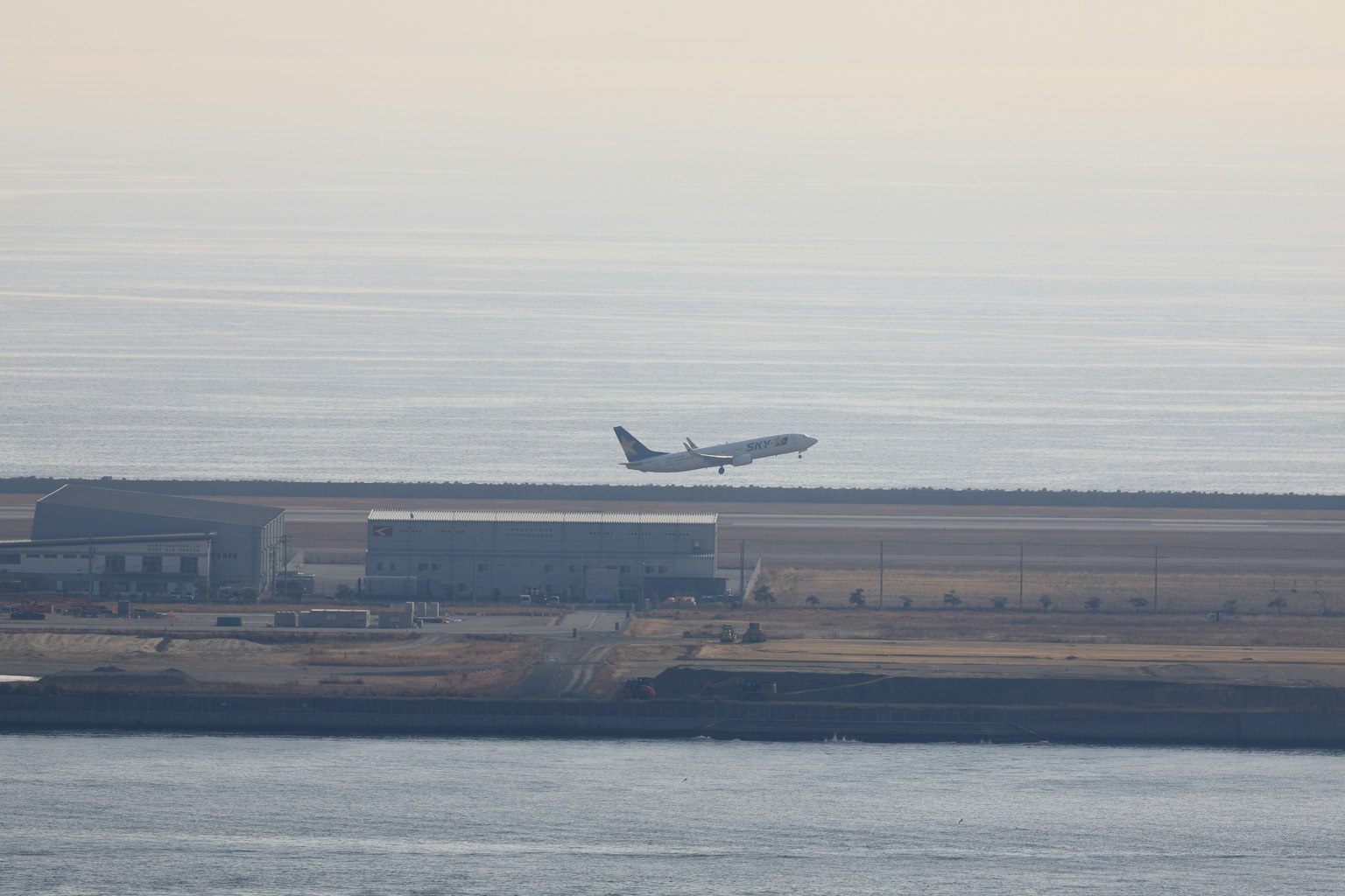 Vista lejana de un avión aterrizando en una pista de aeropuerto