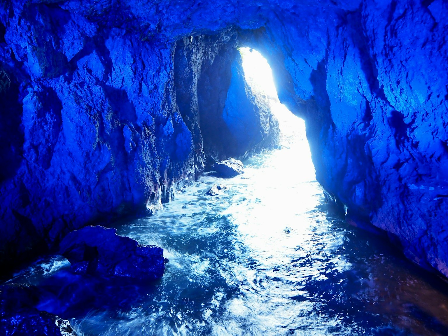 Dentro de una cueva azul con agua brillante y luz
