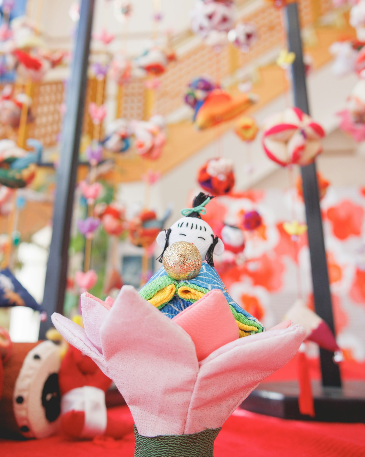 Poupée traditionnelle assise sur une belle fleur avec des décorations colorées en arrière-plan