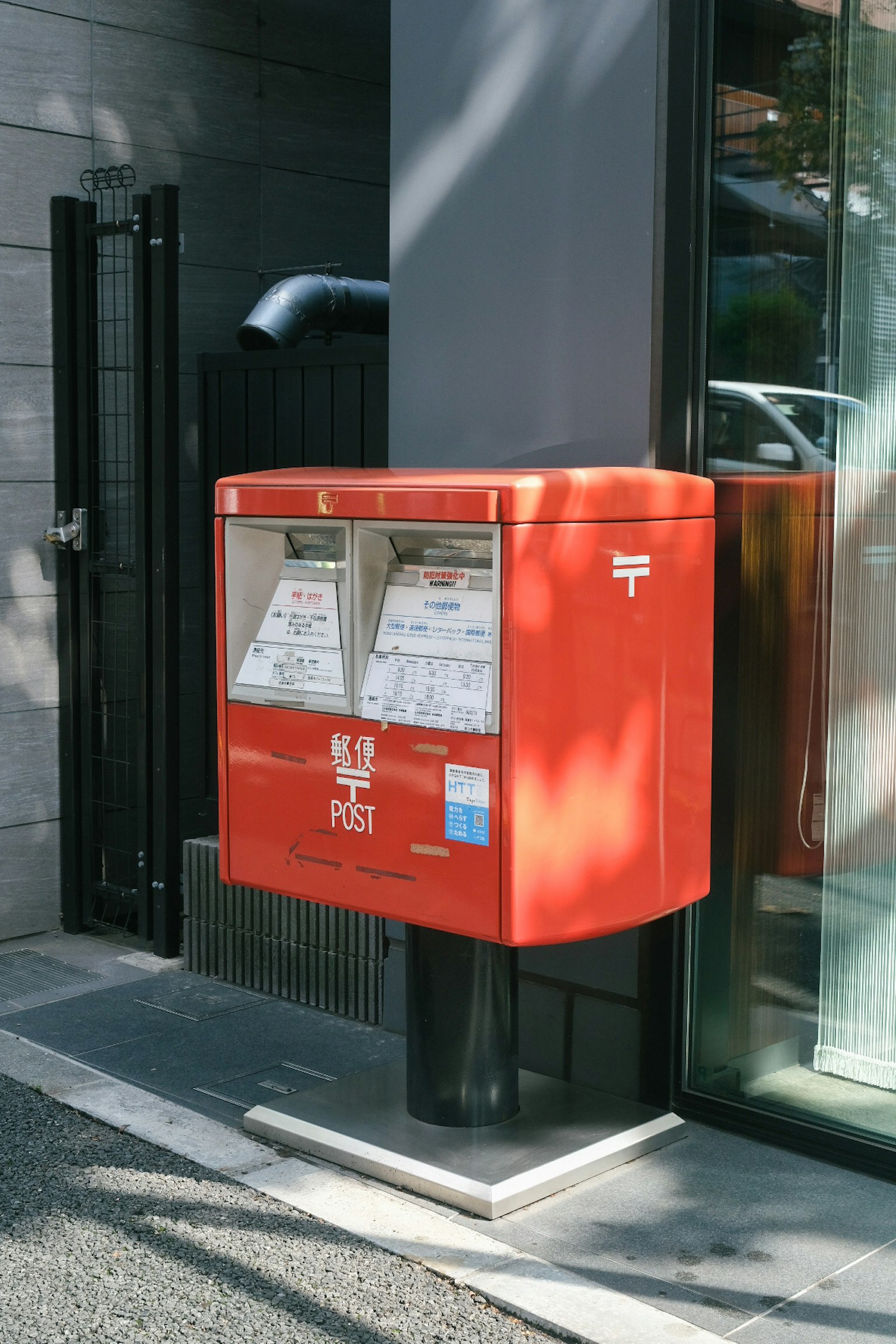 Hộp thư đỏ nằm trước một tòa nhà