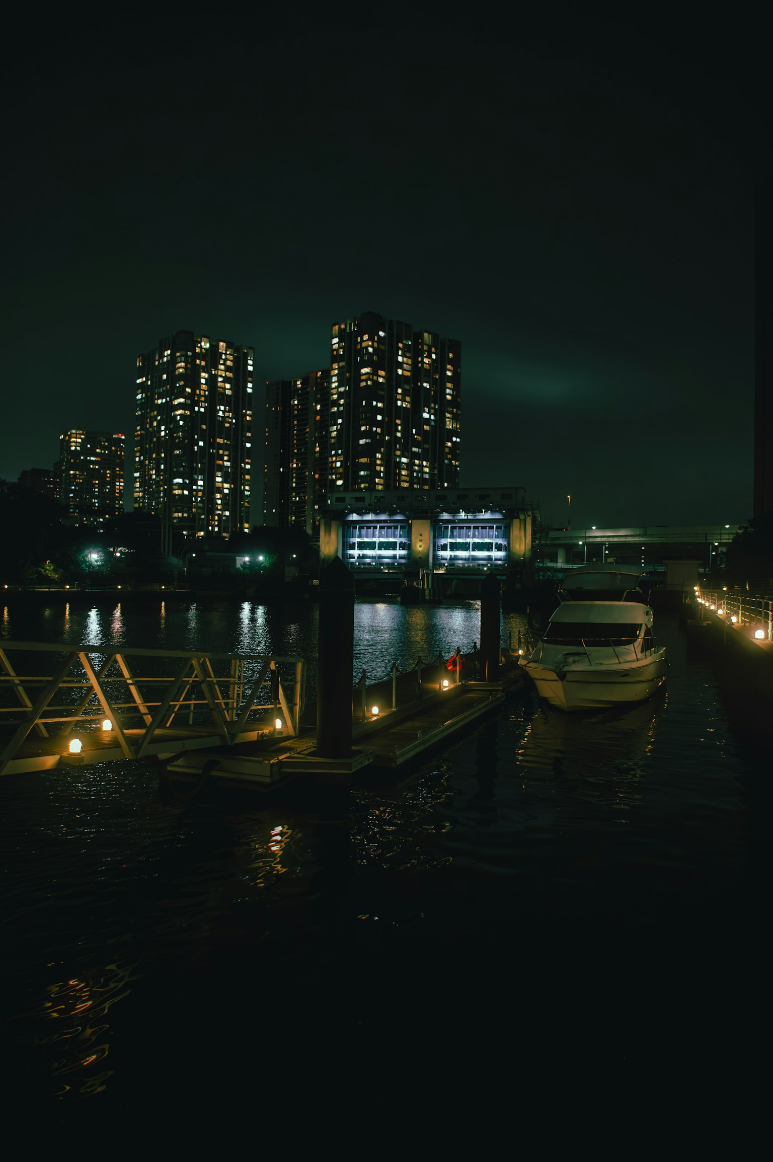 夜晚停靠的船只和灯光照亮的高层建筑