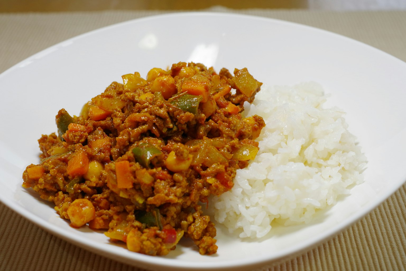 Poulet sauté aux légumes servi avec du riz sur une assiette blanche