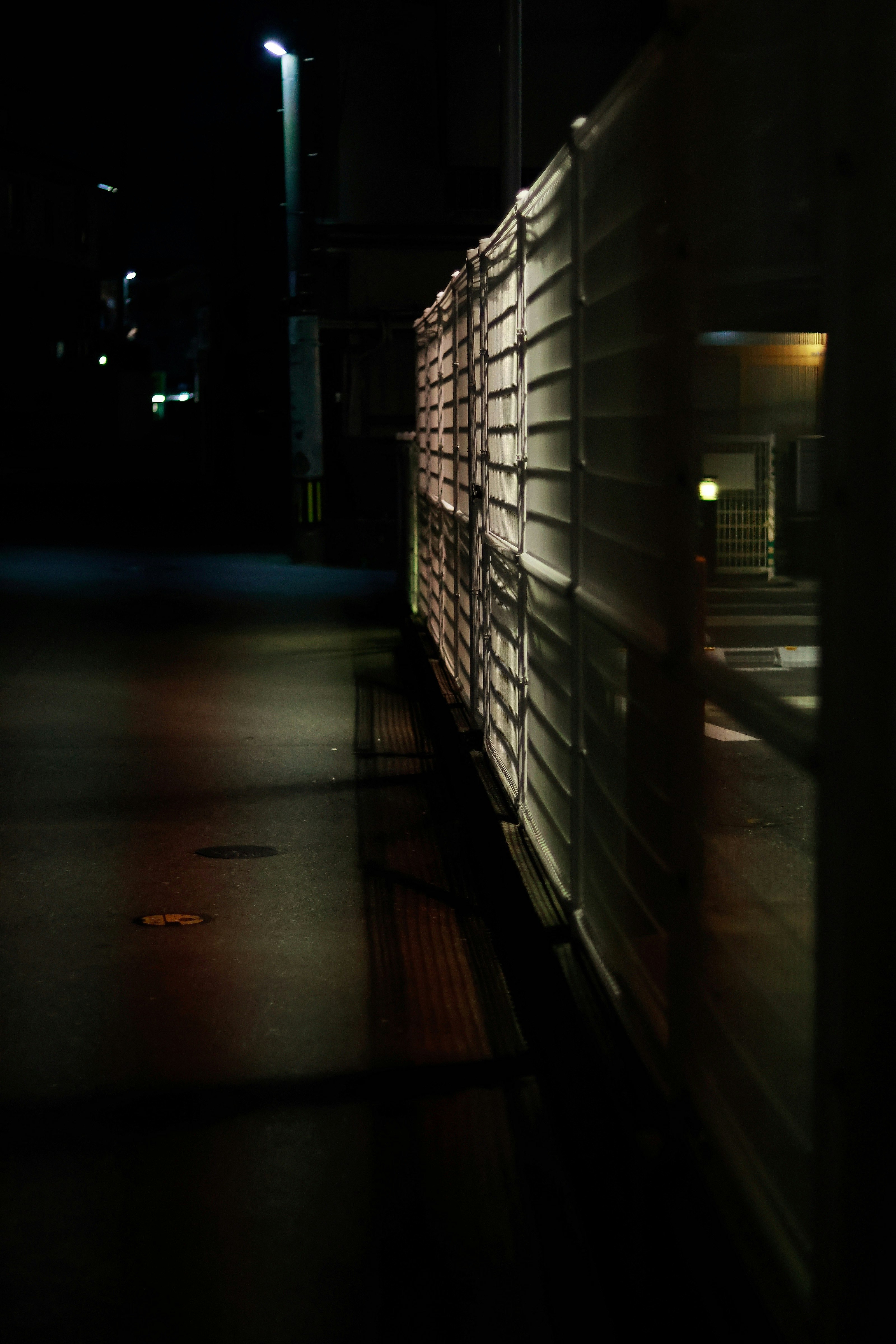 夜の路地で街灯に照らされた壁と歩道