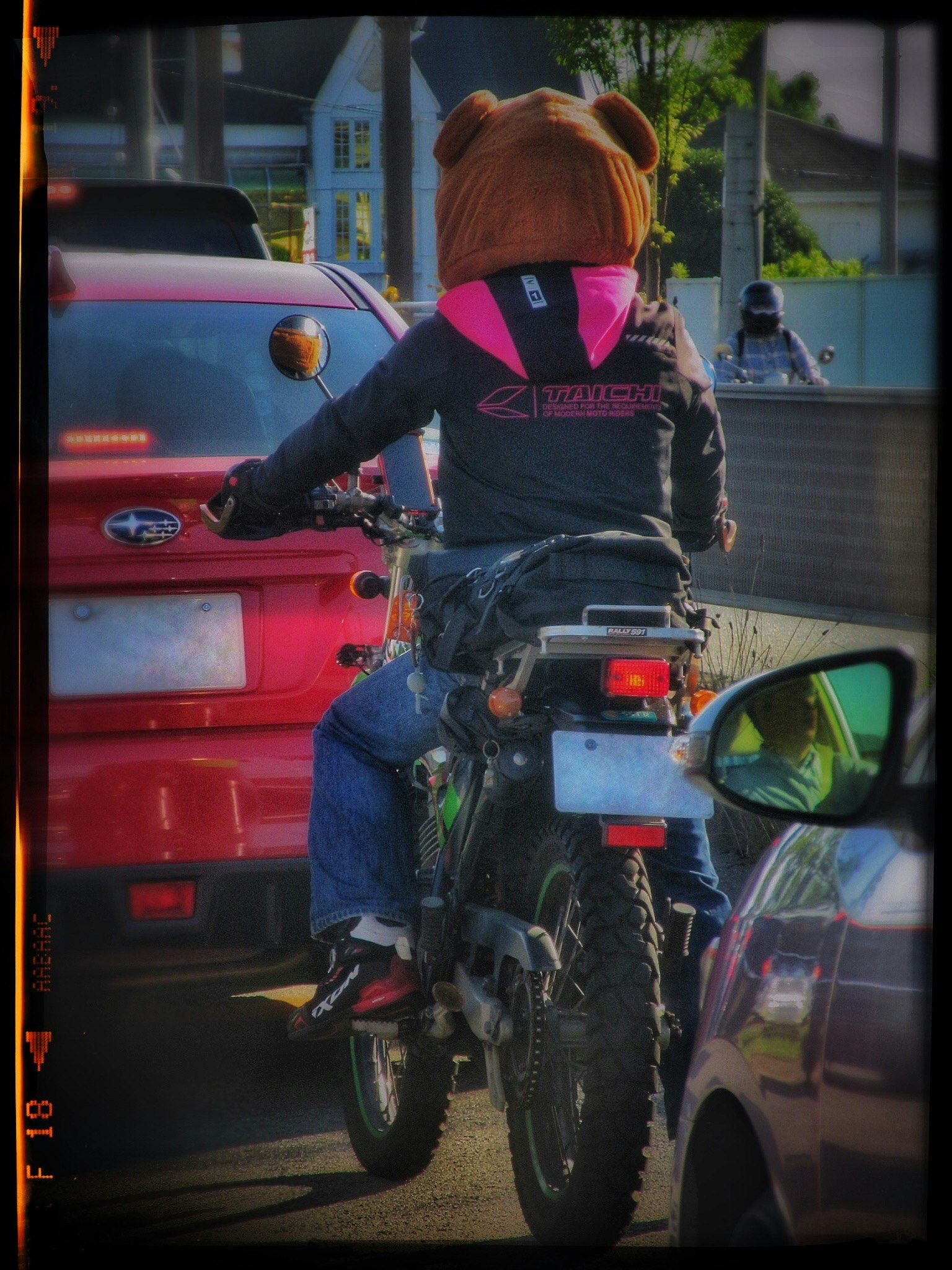 Orang yang mengenakan helm berbentuk beruang mengendarai sepeda motor dalam lalu lintas