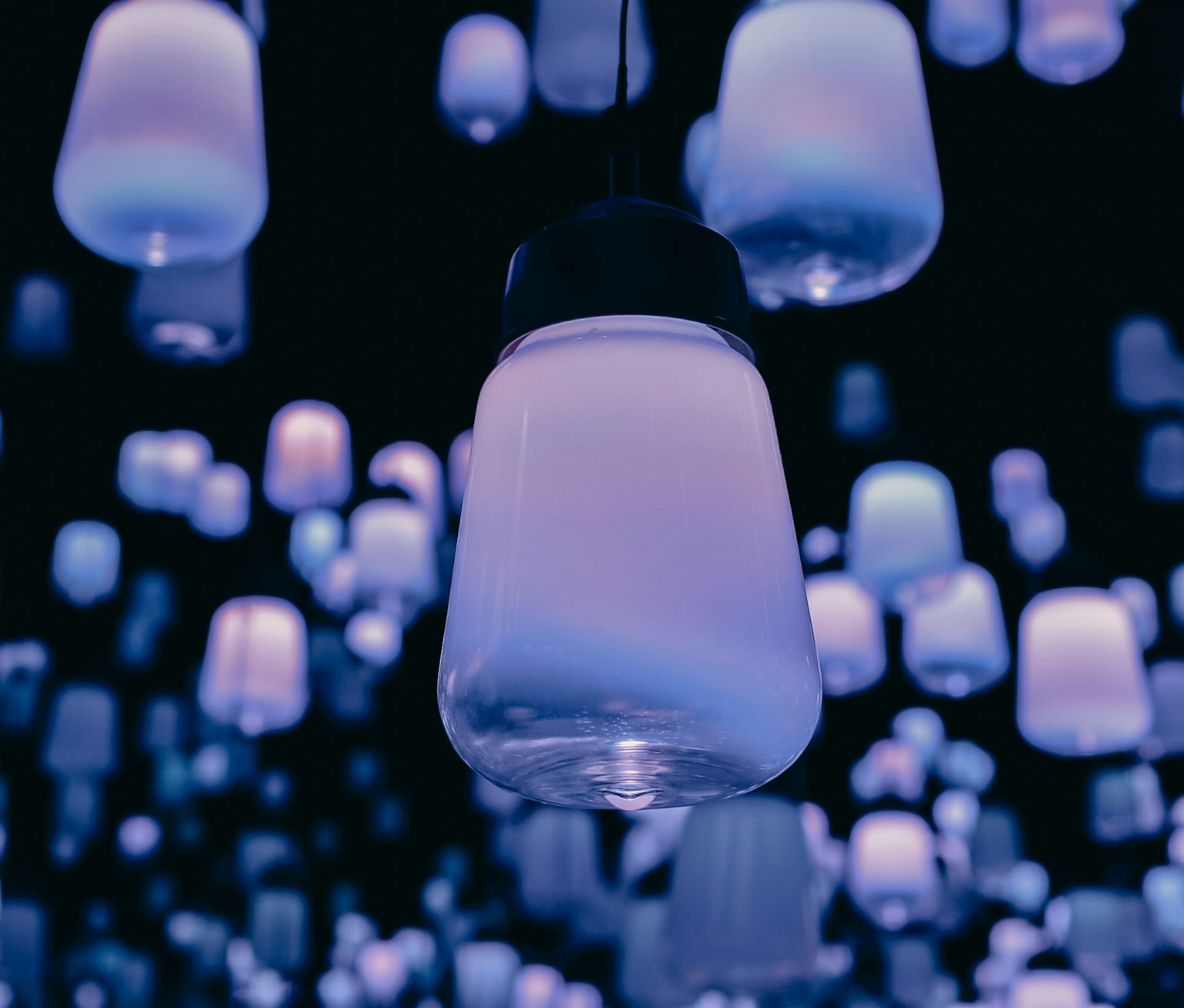 A scene with numerous hanging lamps illuminated in blue light