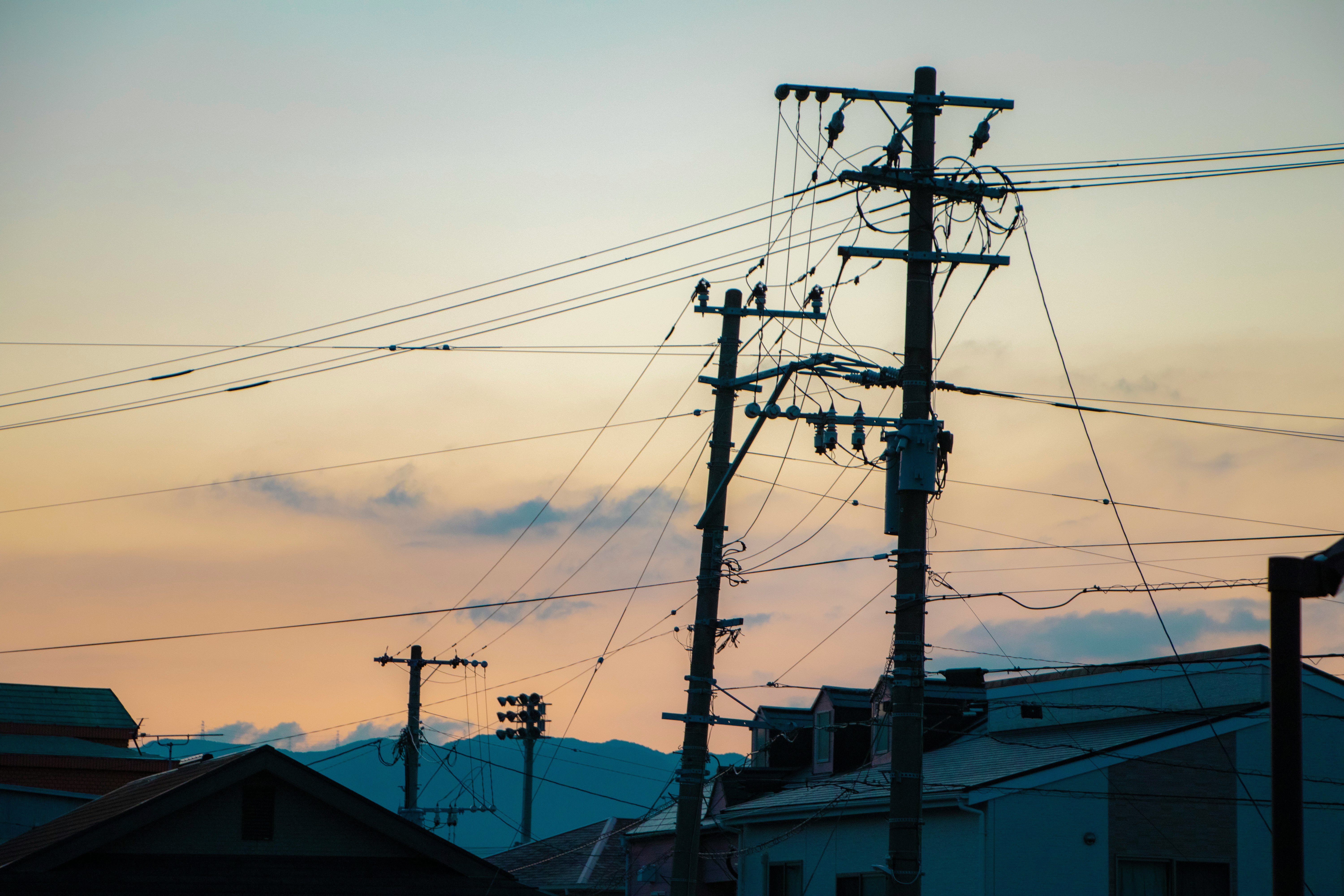 夕暮れの空と電線が交差する住宅街の電柱