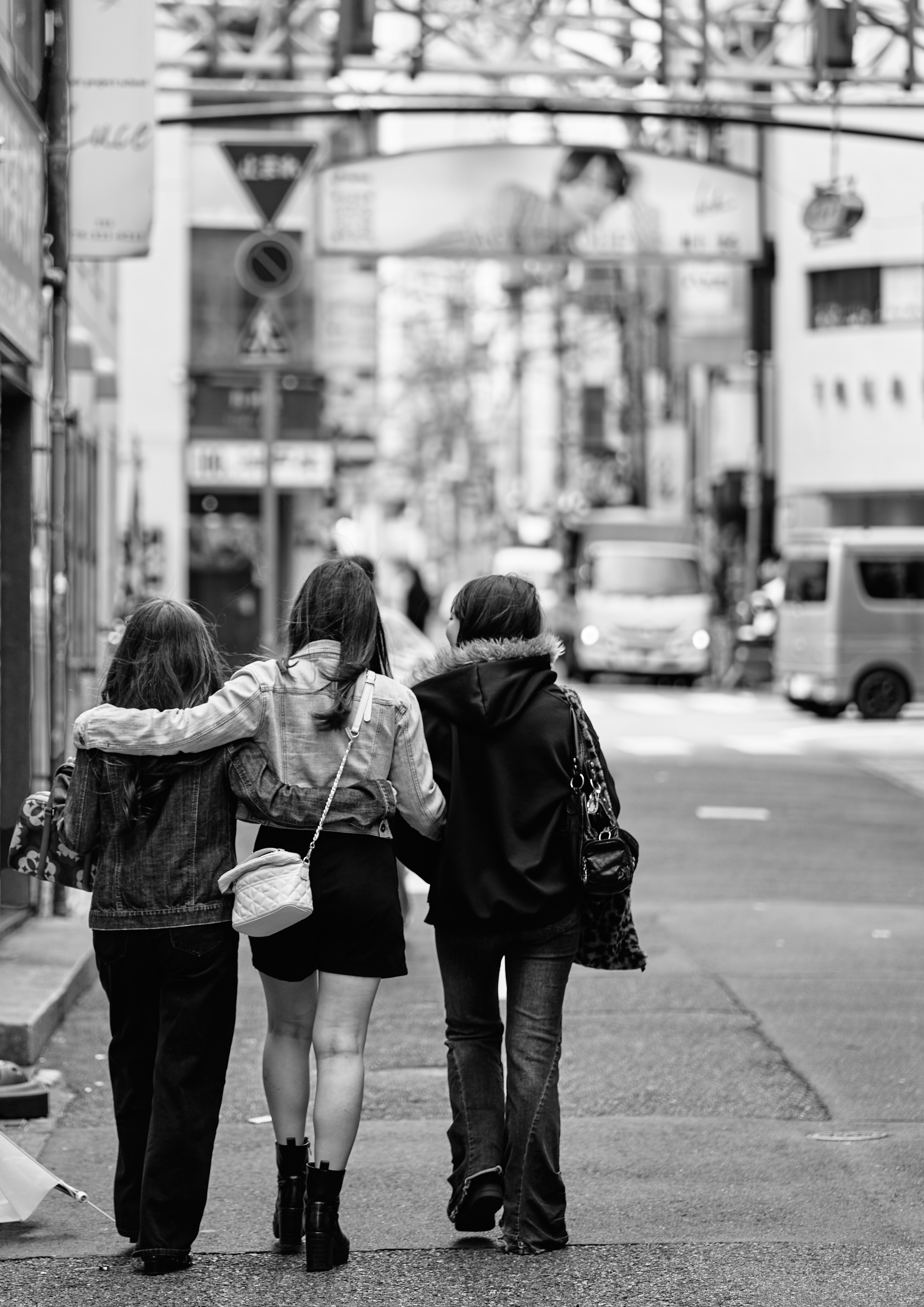 路地で寄り添う3人の背中