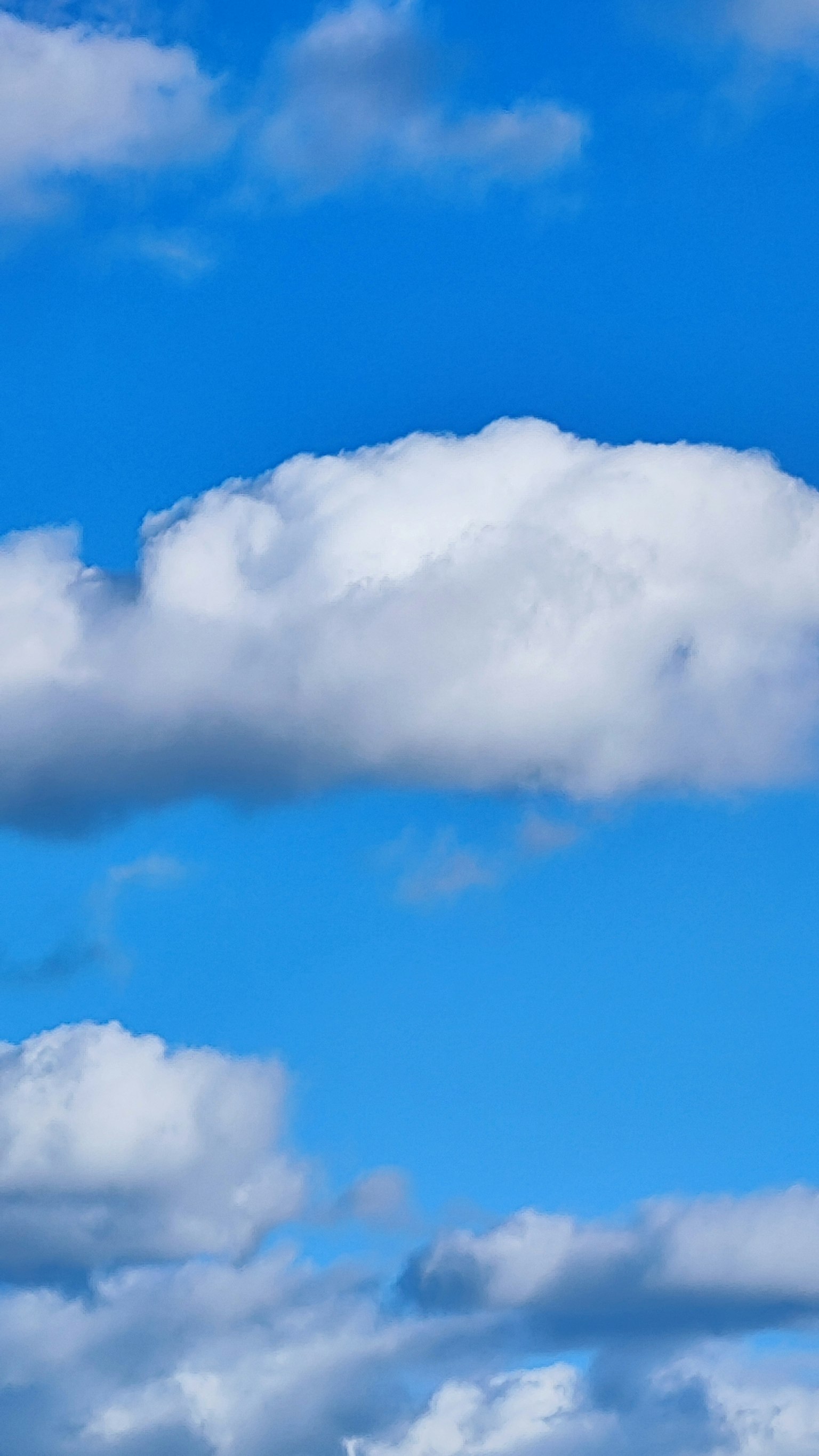 Awan putih mengapung di langit biru