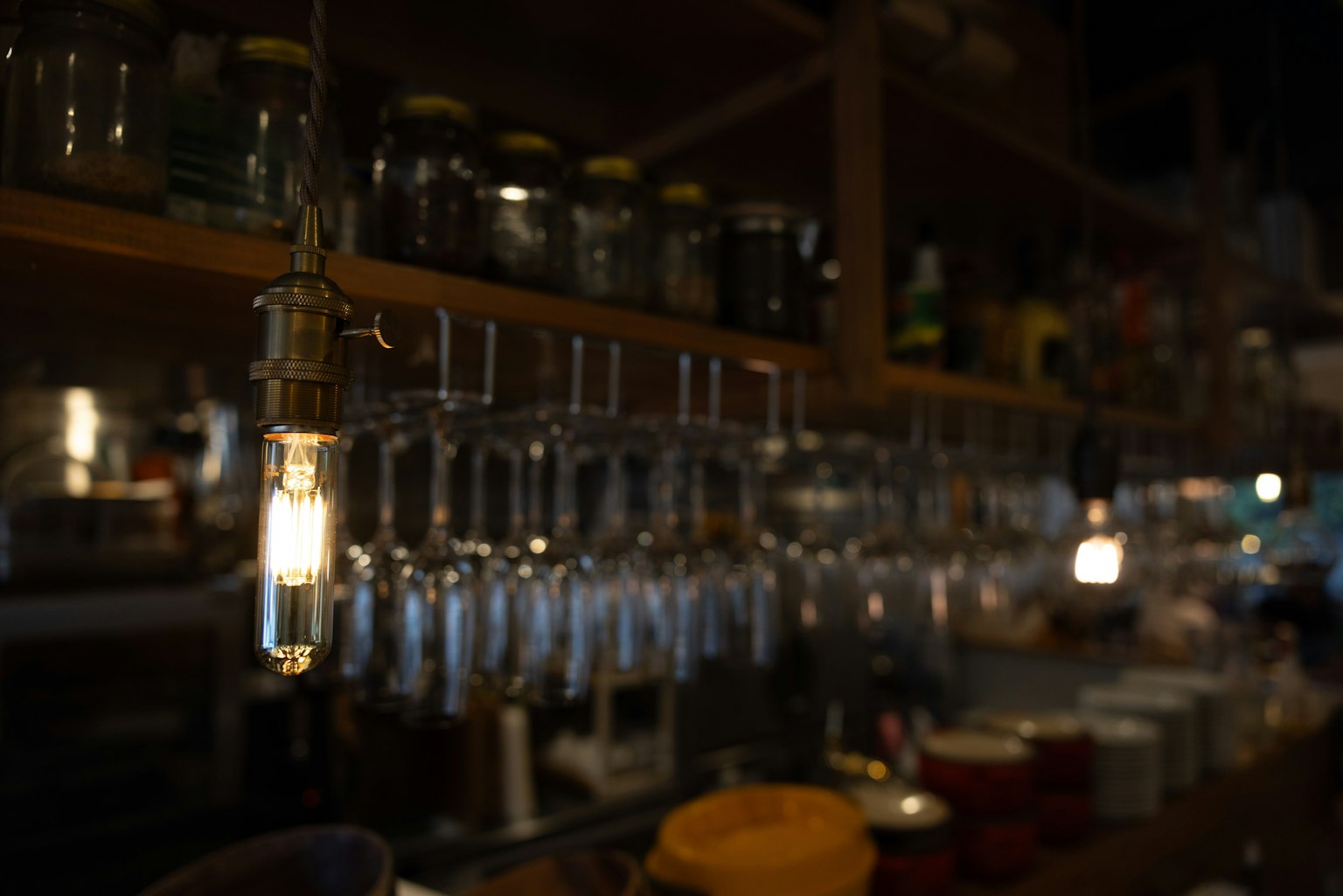 Interno di un caffè con luci appese e scaffali di barattoli di vetro