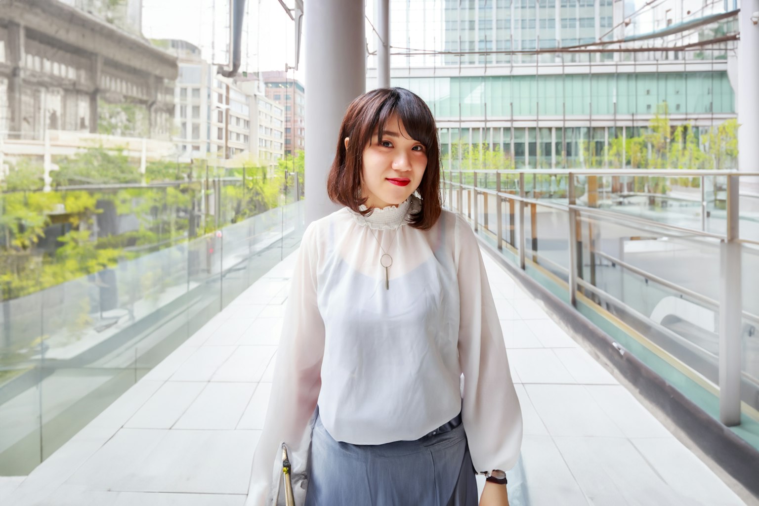 도시 환경에 서 있는 흰색 블라우스를 입은 여성