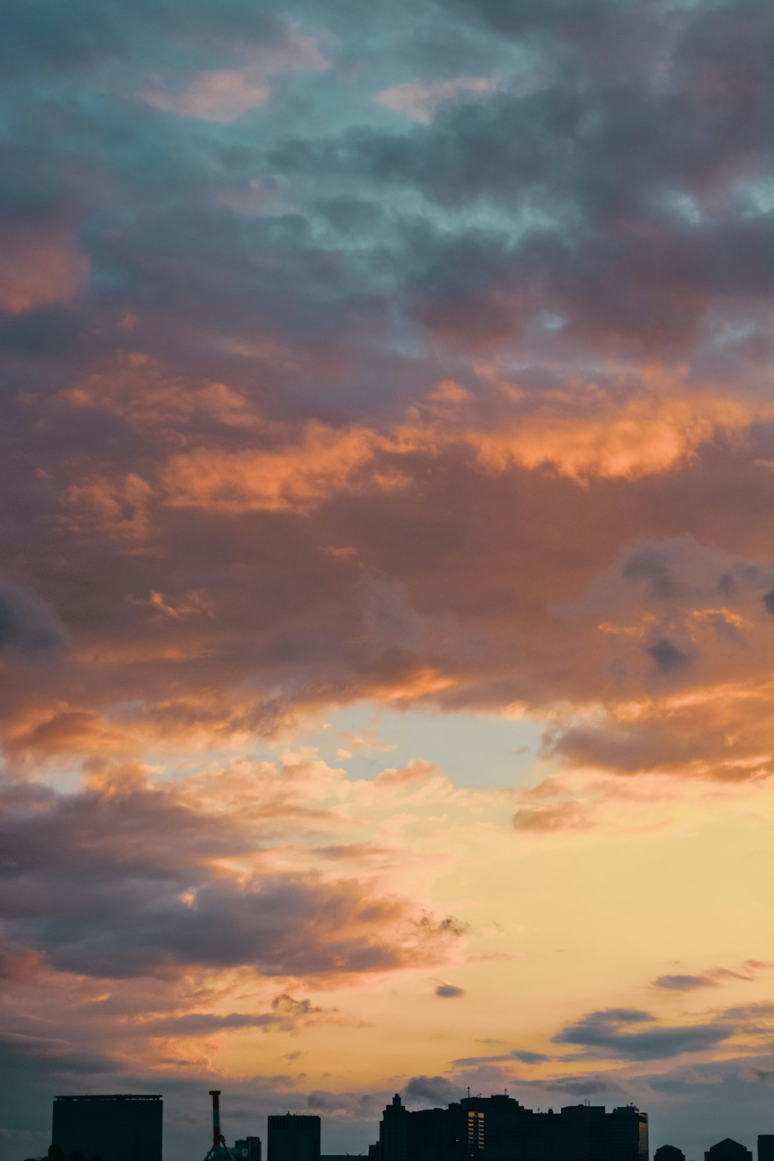 Cielo al tramonto con nuvole e silhouette di edifici