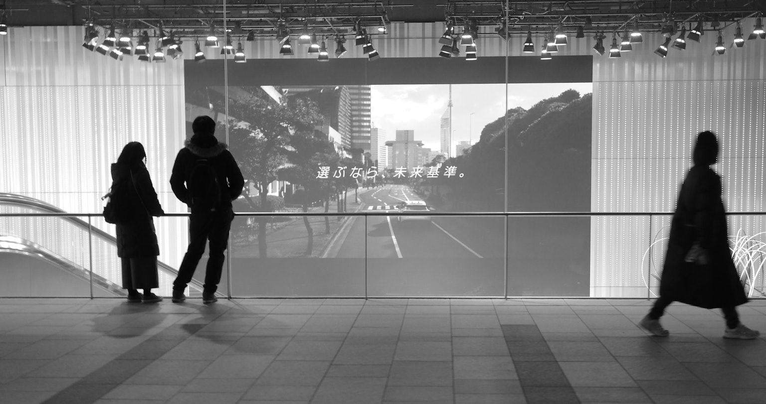 Two observers and a passerby against a black and white cityscape
