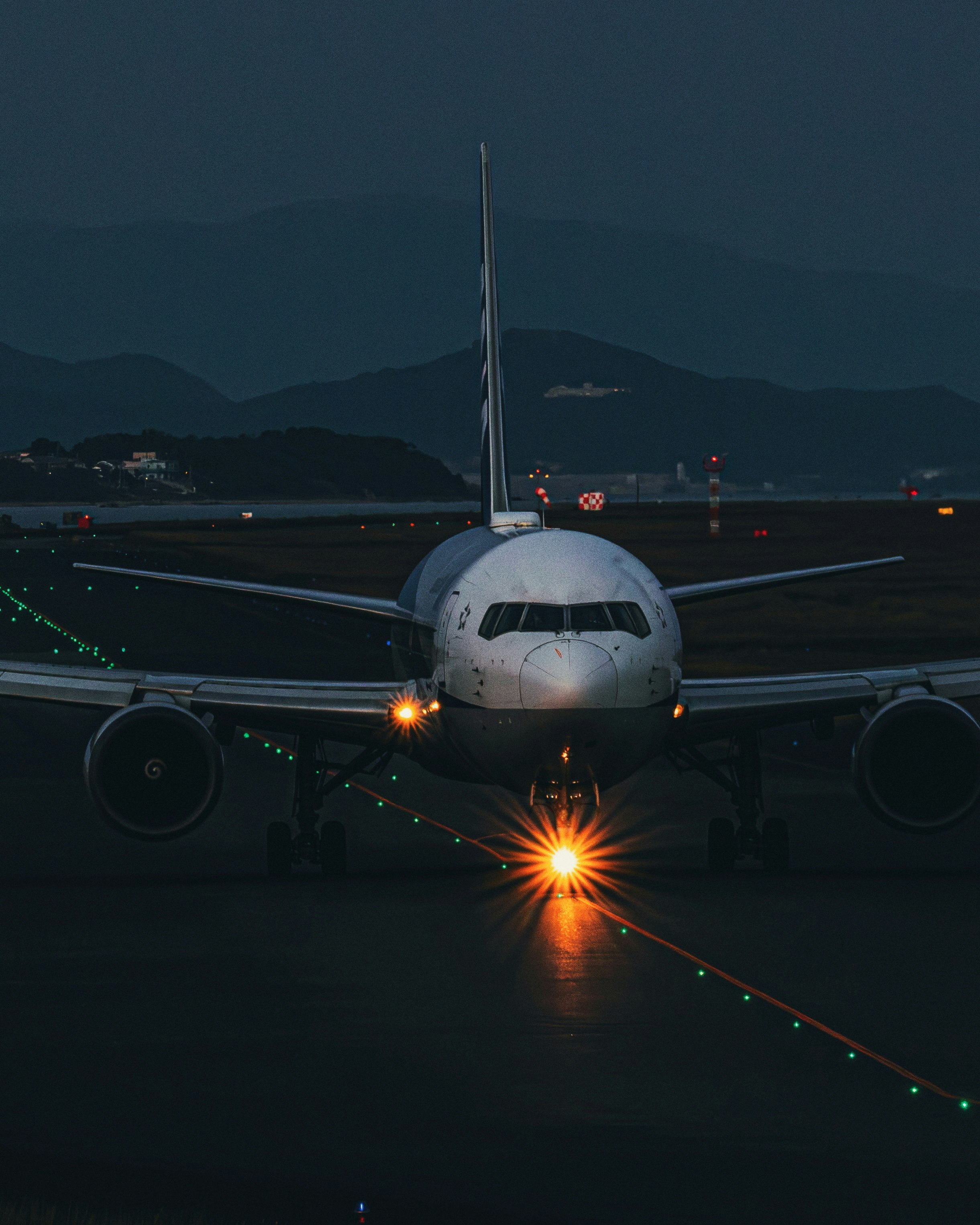 宇部空港の滑走路でライトを点けた飛行機の前景