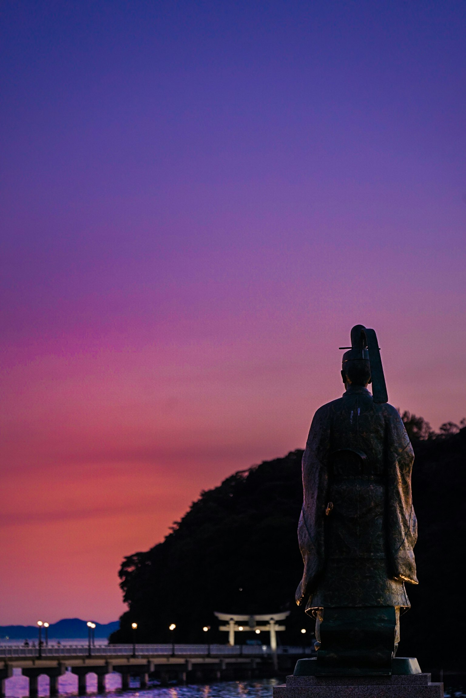 Silueta de una estatua contra un cielo de atardecer