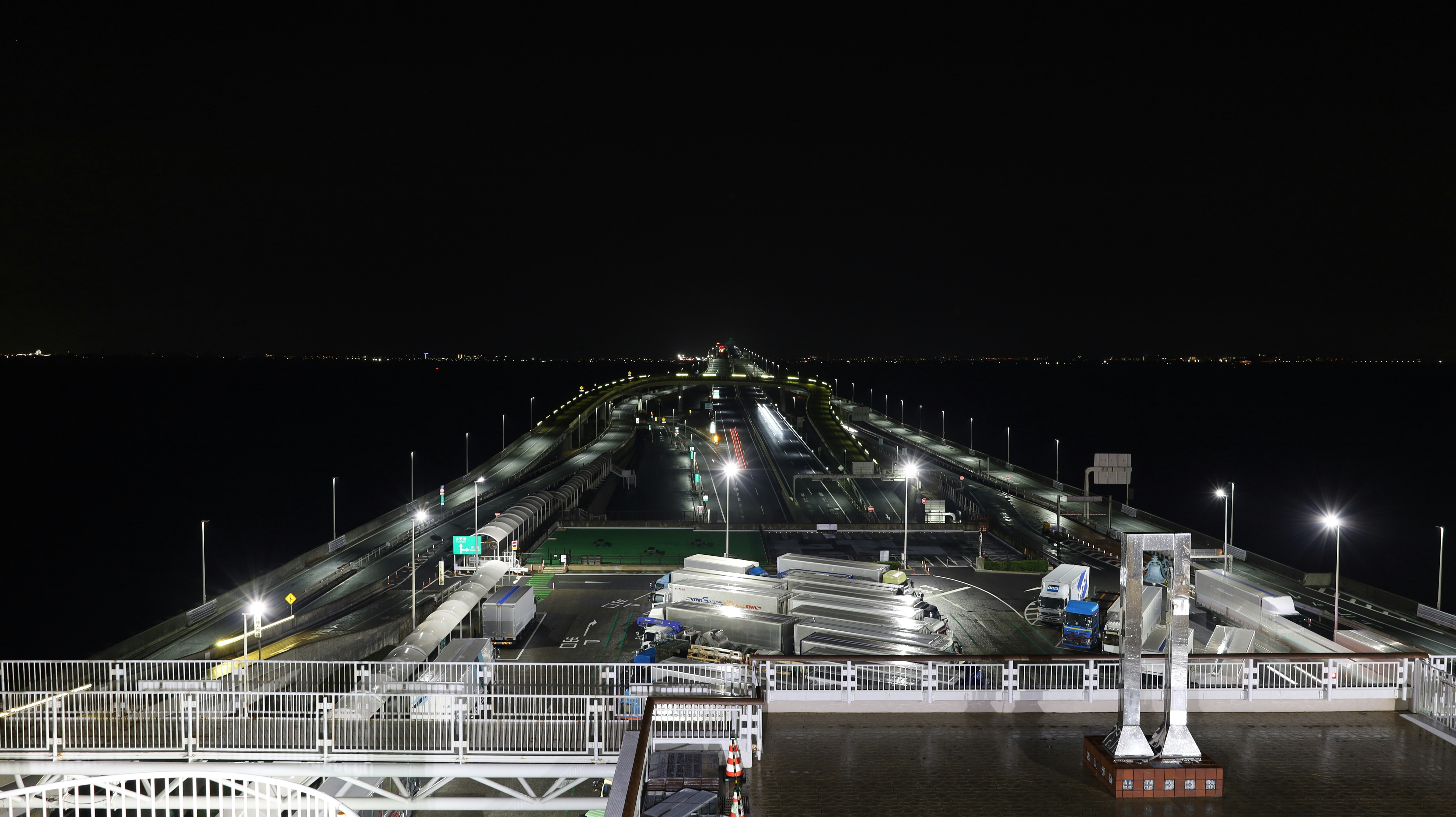 夜の港湾に並ぶ照明付きの防波堤と岸壁