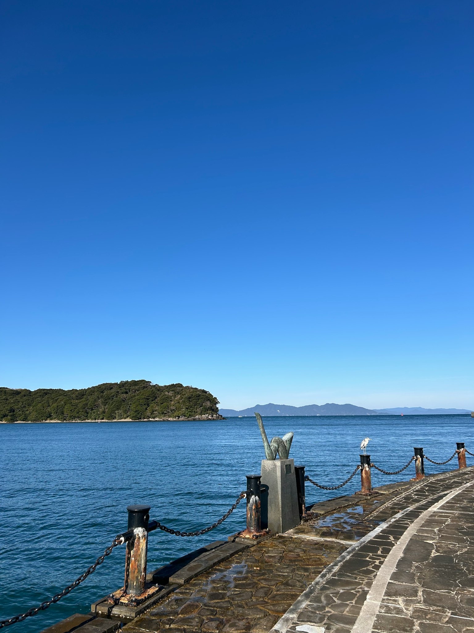 A scenic view of a pier with a clear blue sky and calm sea