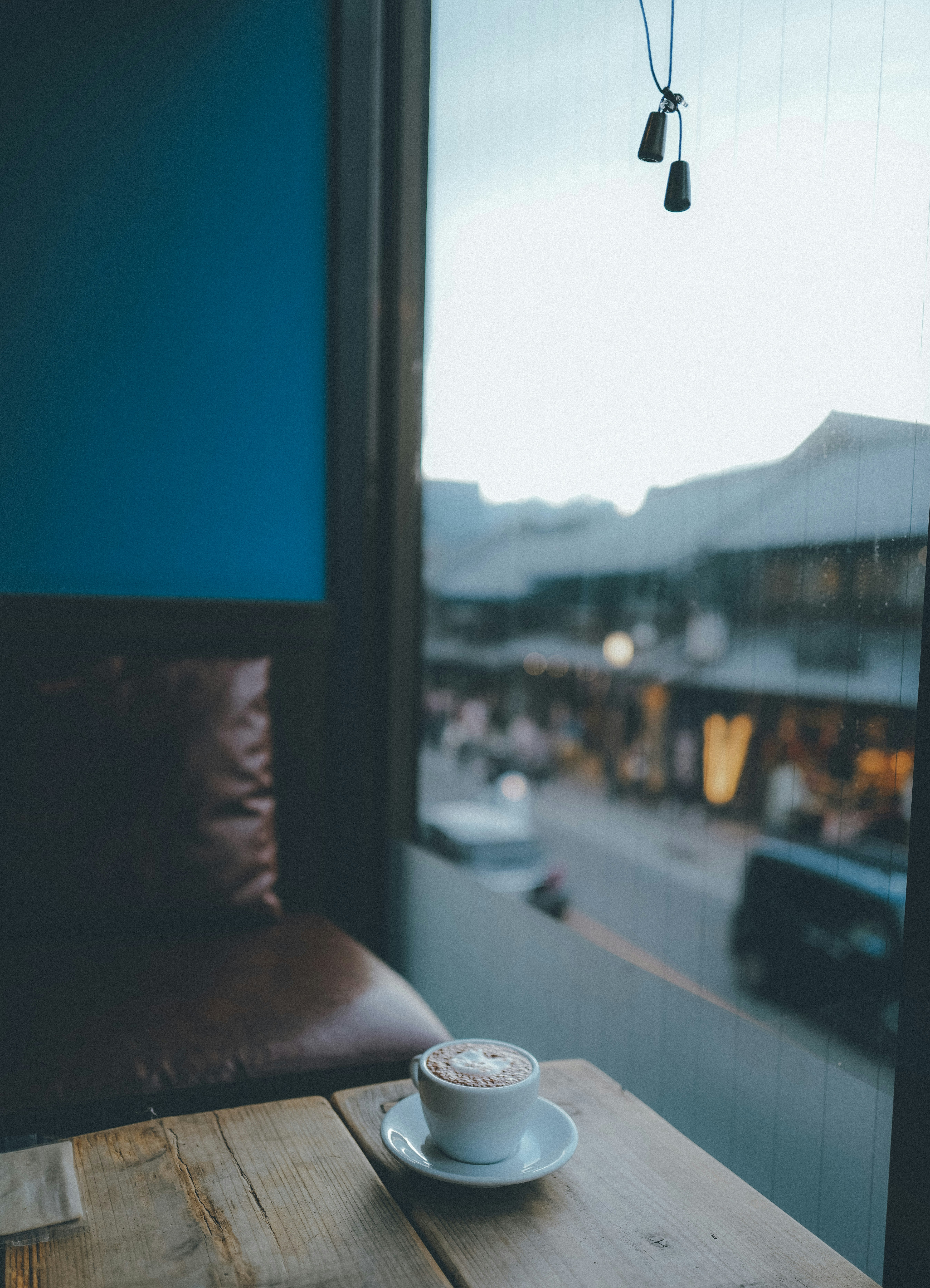 coffee cup on a table by a window with a city view