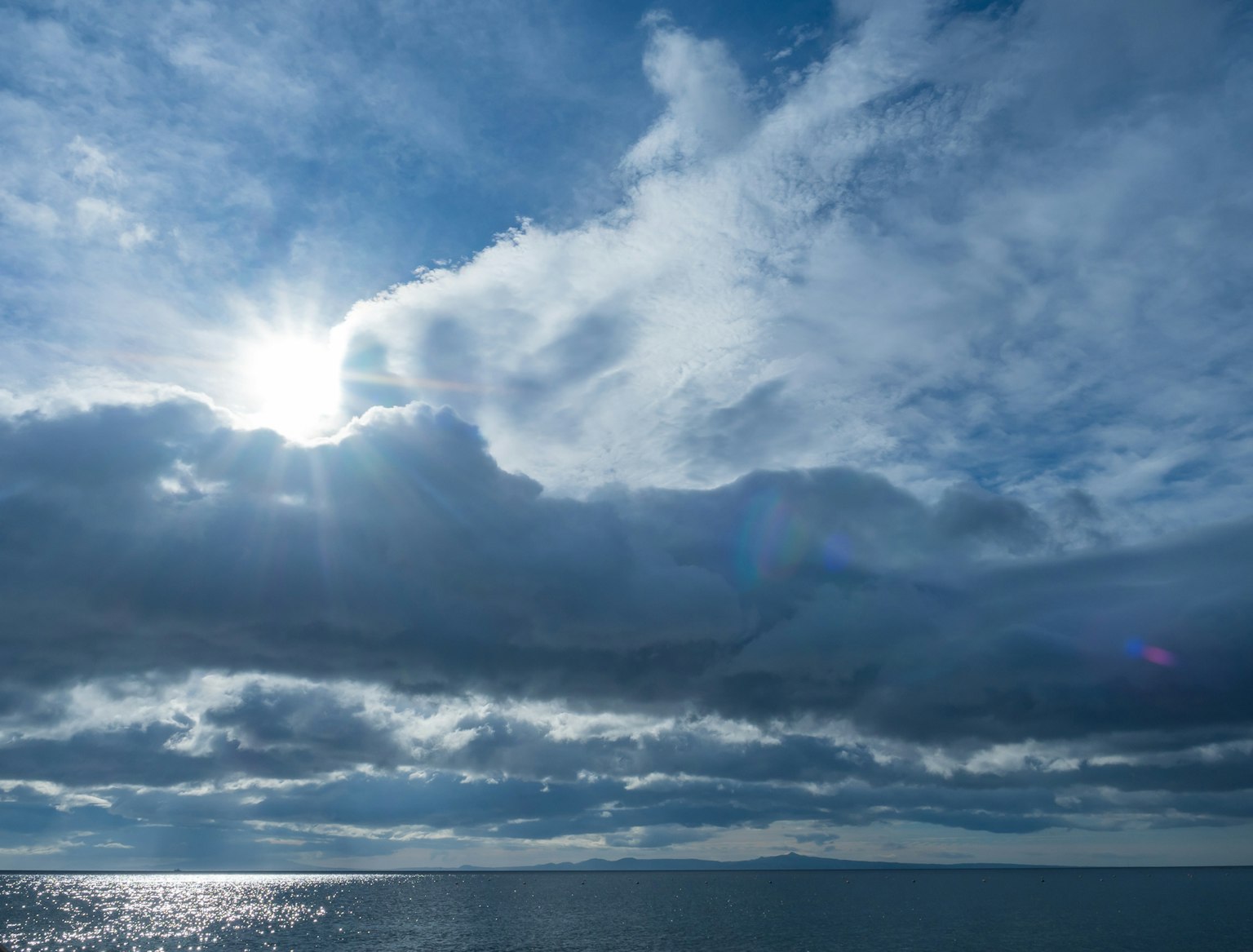 青い空と雲の下に反射する海の風景