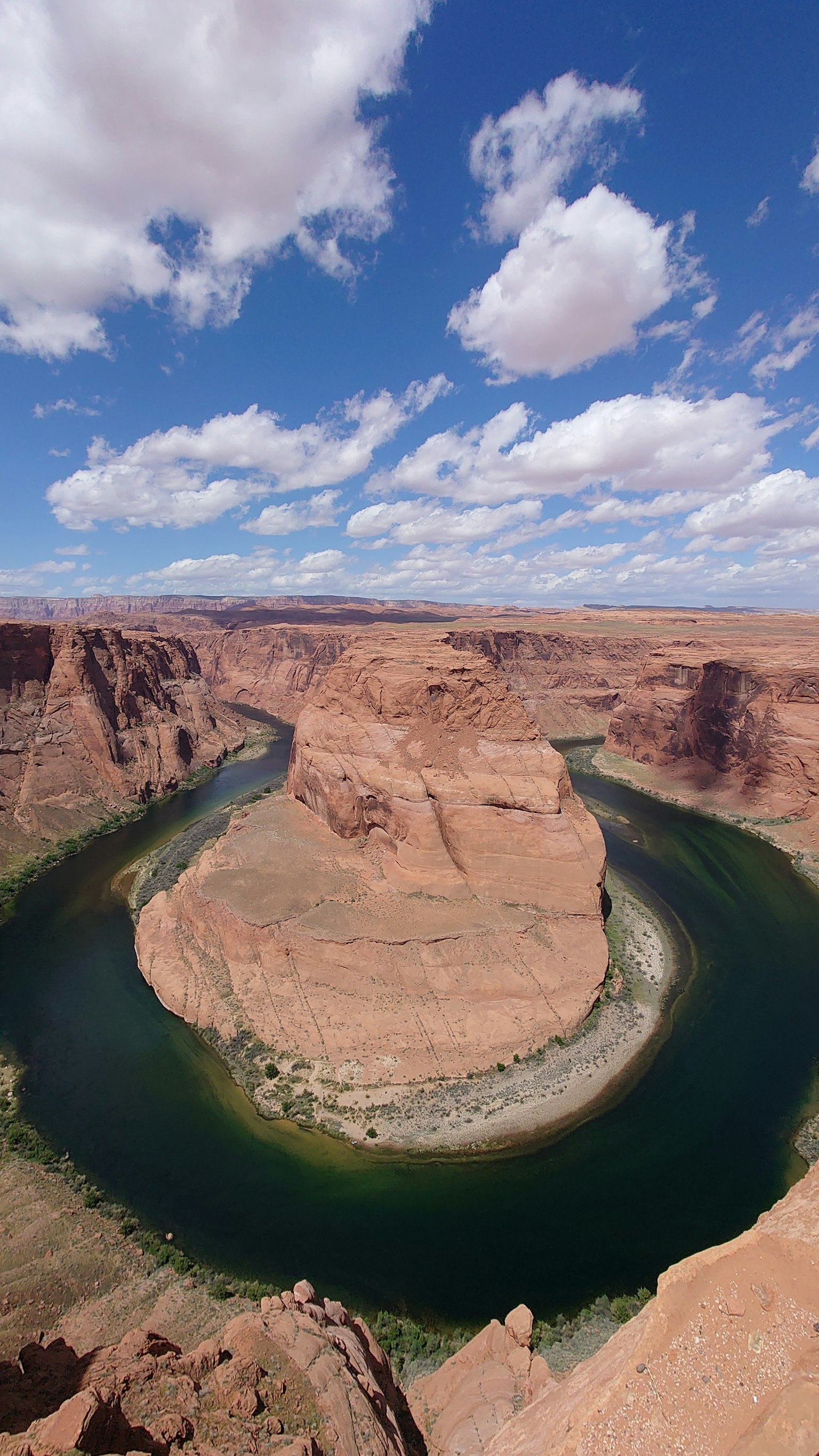 Atemberaubender Blick auf Horseshoe Bend mit blauem Himmel und weißen Wolken grünem Fluss und roten Felsformationen