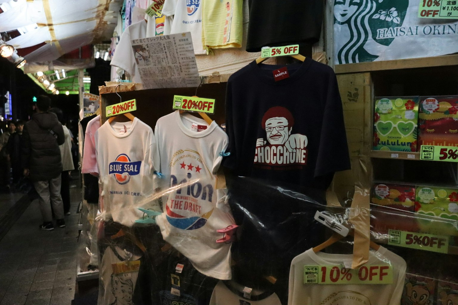 Esposizione di T-shirt in vendita al mercato Vari design e etichette di prezzo visibili