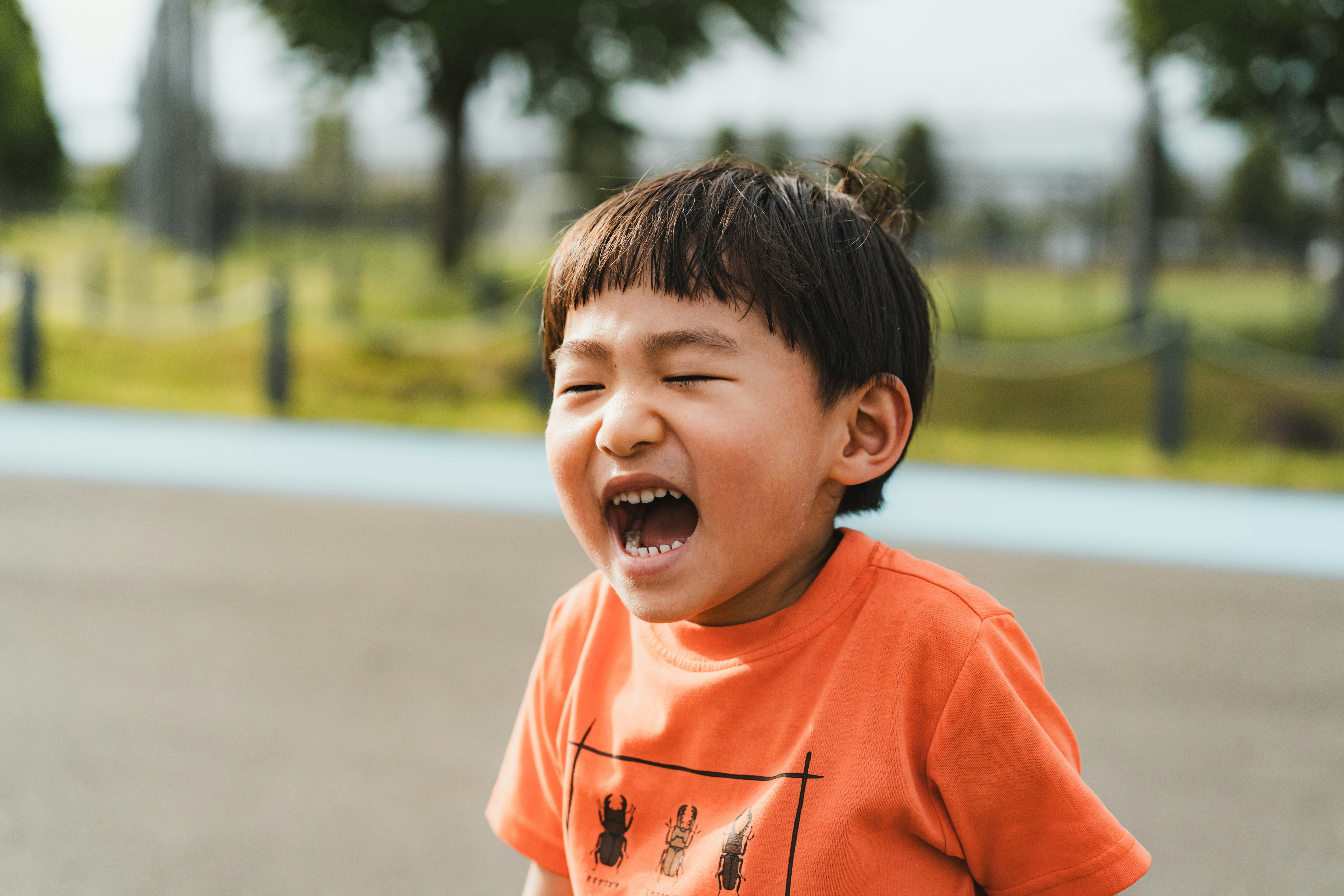 anak laki-laki tersenyum di taman