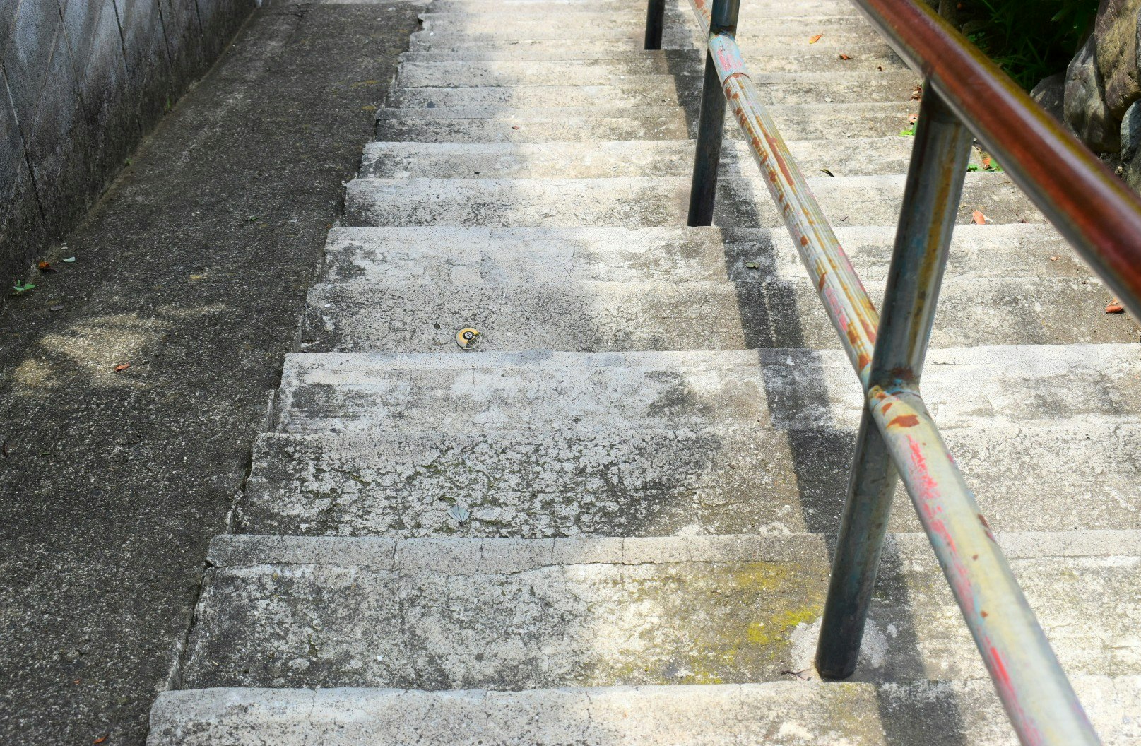 昼間の石階段と手すりのある通路