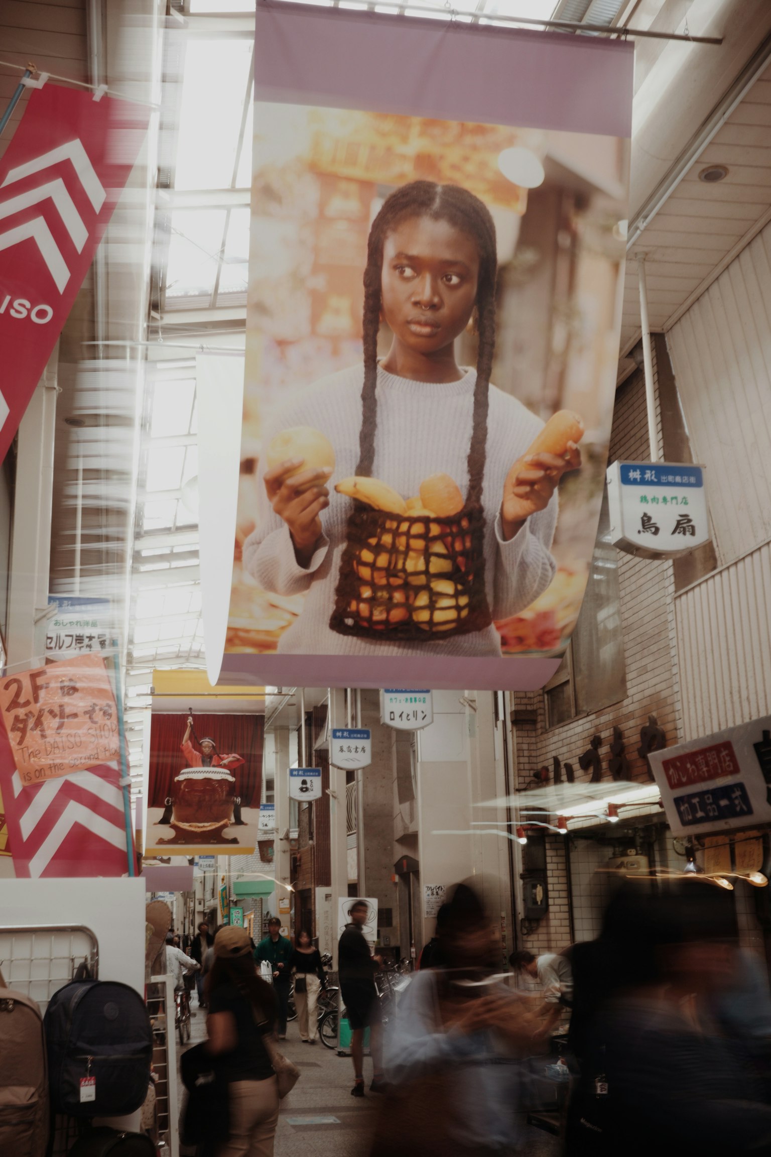 A large poster of a woman holding food stands out in a busy commercial area