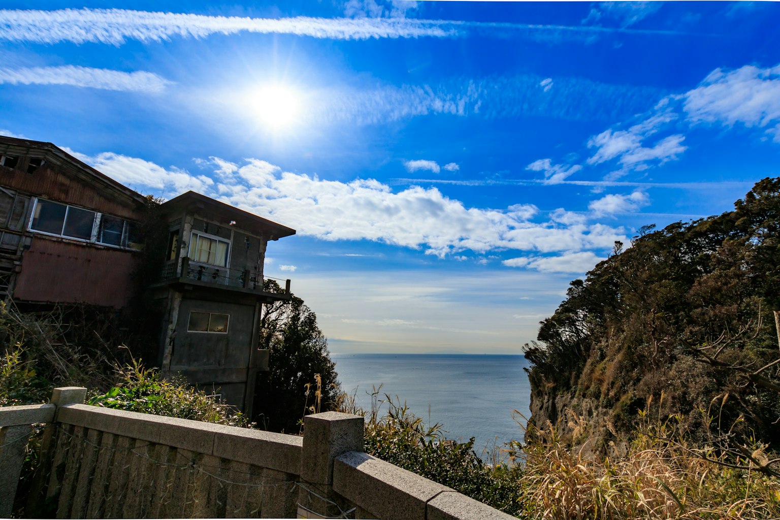 Malersiche Aussicht auf ein Haus mit Ozean- und Himmelshintergrund, blauer Himmel und Wolken
