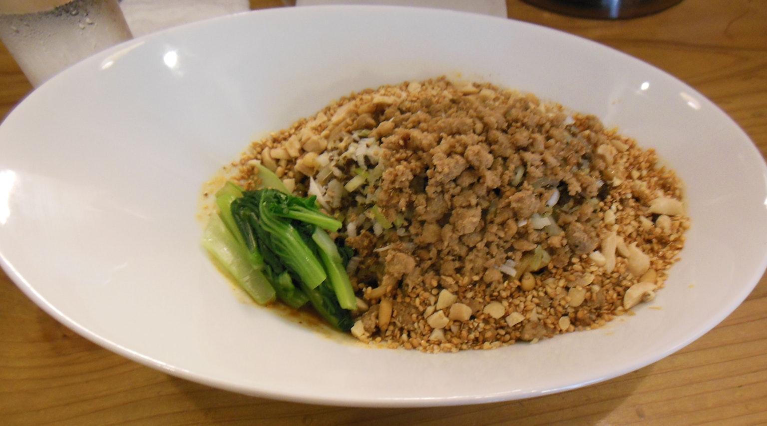香米飯上撒有碎花生和綠色蔬菜的菜餚