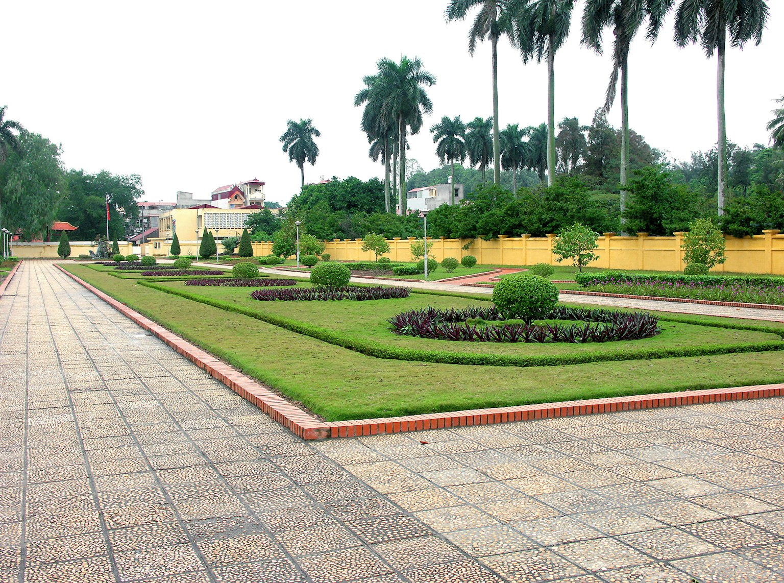 Pemandangan taman luas dengan rumput terawat dan taman bunga