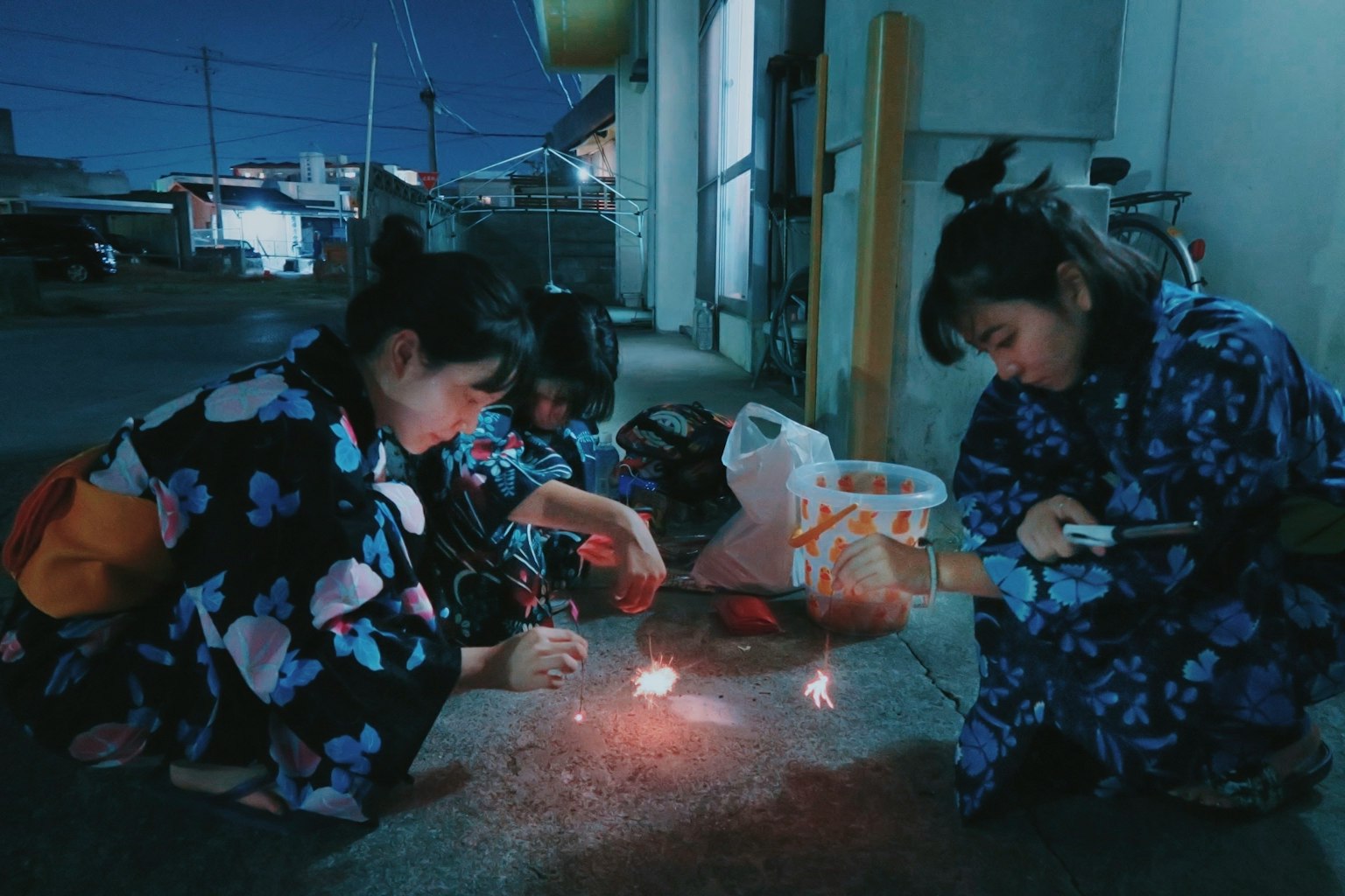 Children in yukata enjoying fireworks at night