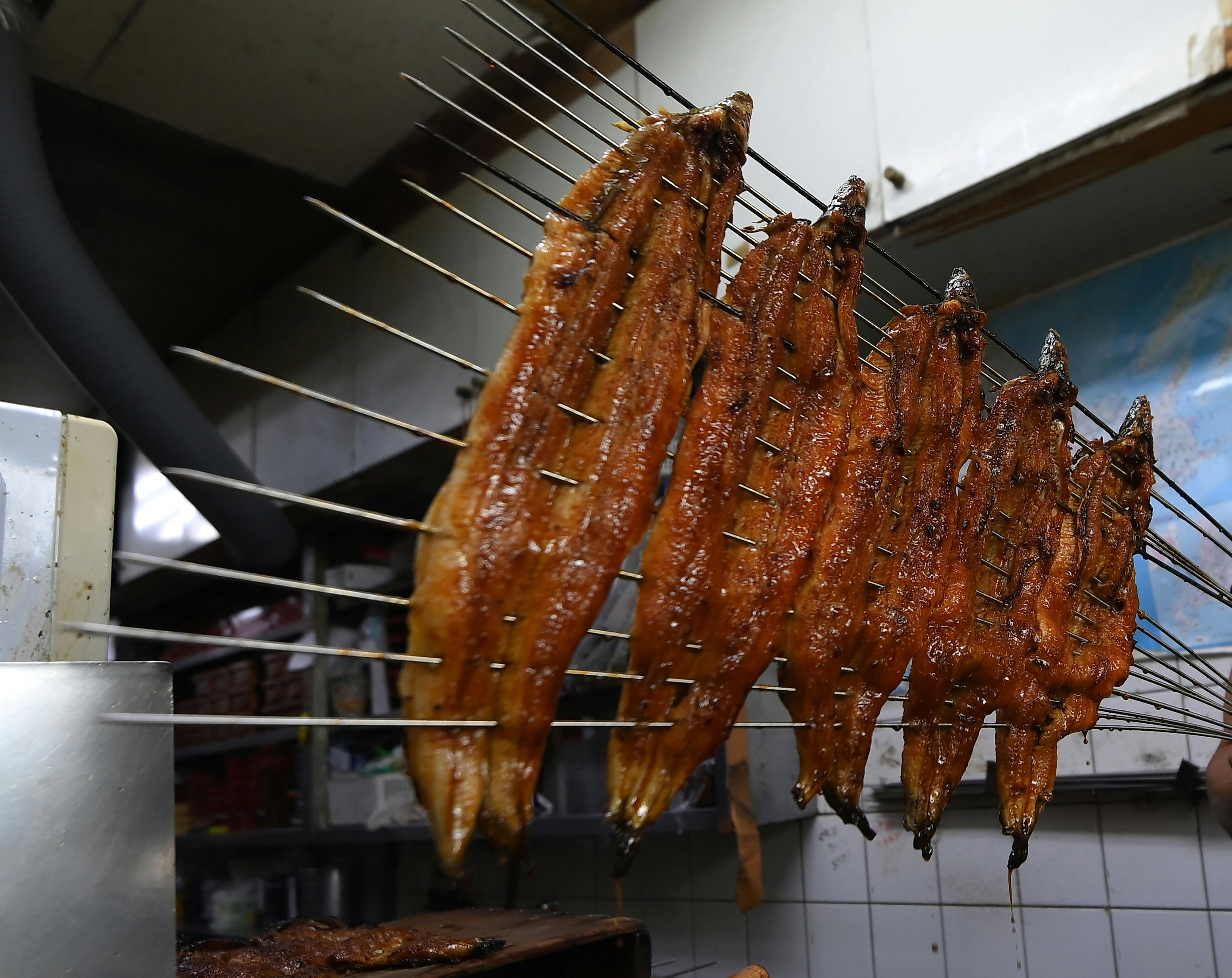 串に刺さった焼き魚の屋台のような調理風景