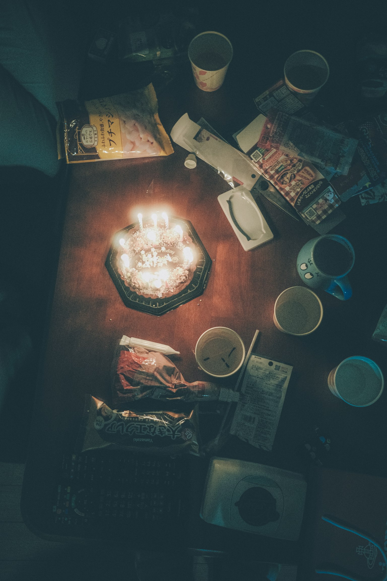 테이블 위에 있는 생일 케이크와 주변의 간식 및 음료