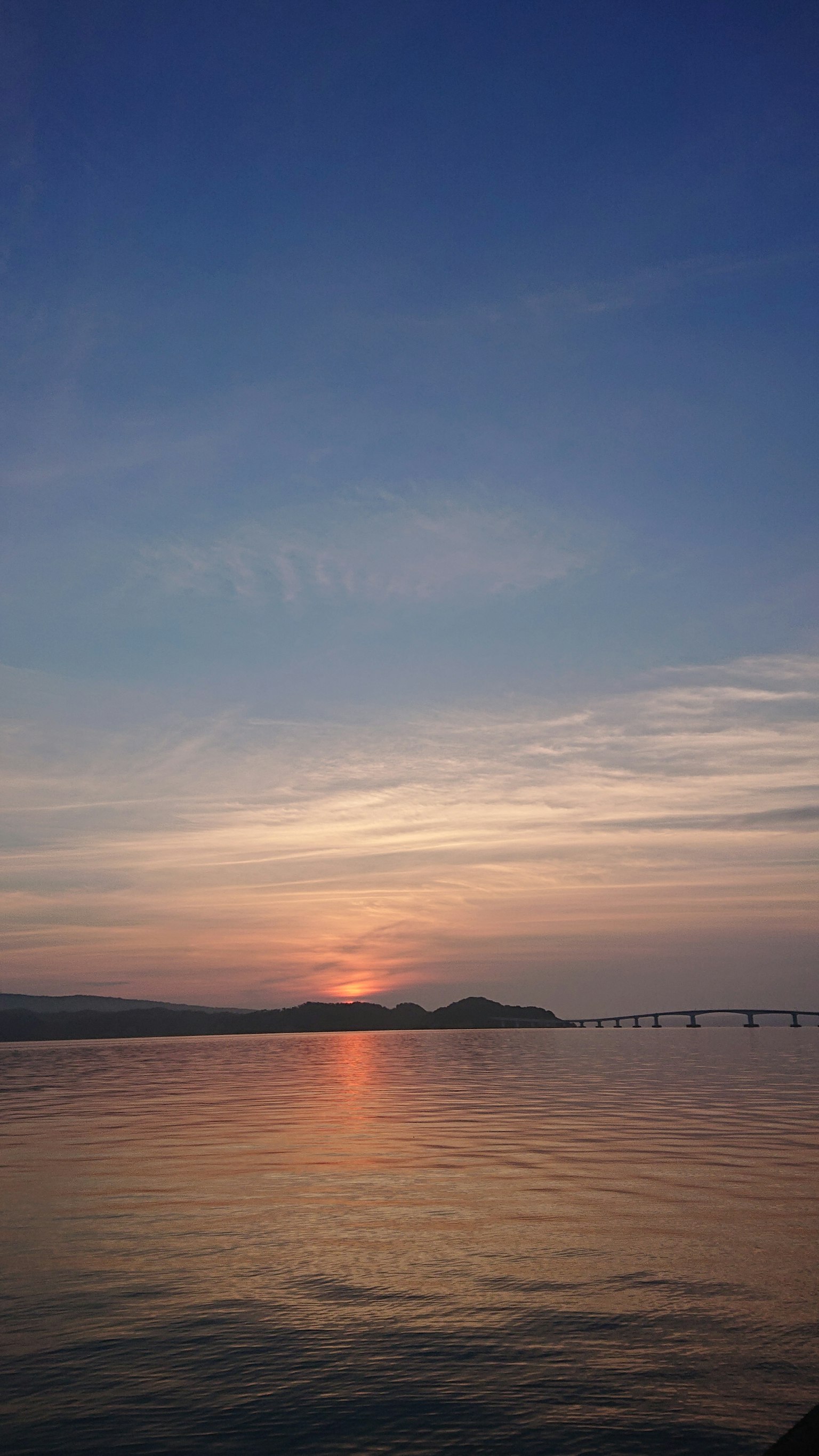 A stunning sunset over a calm sea with gentle waves