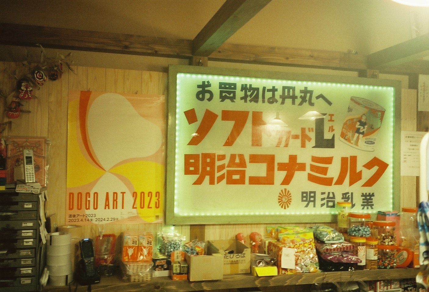 摆满零食的店面货架与“Meiji Konamilk”招牌