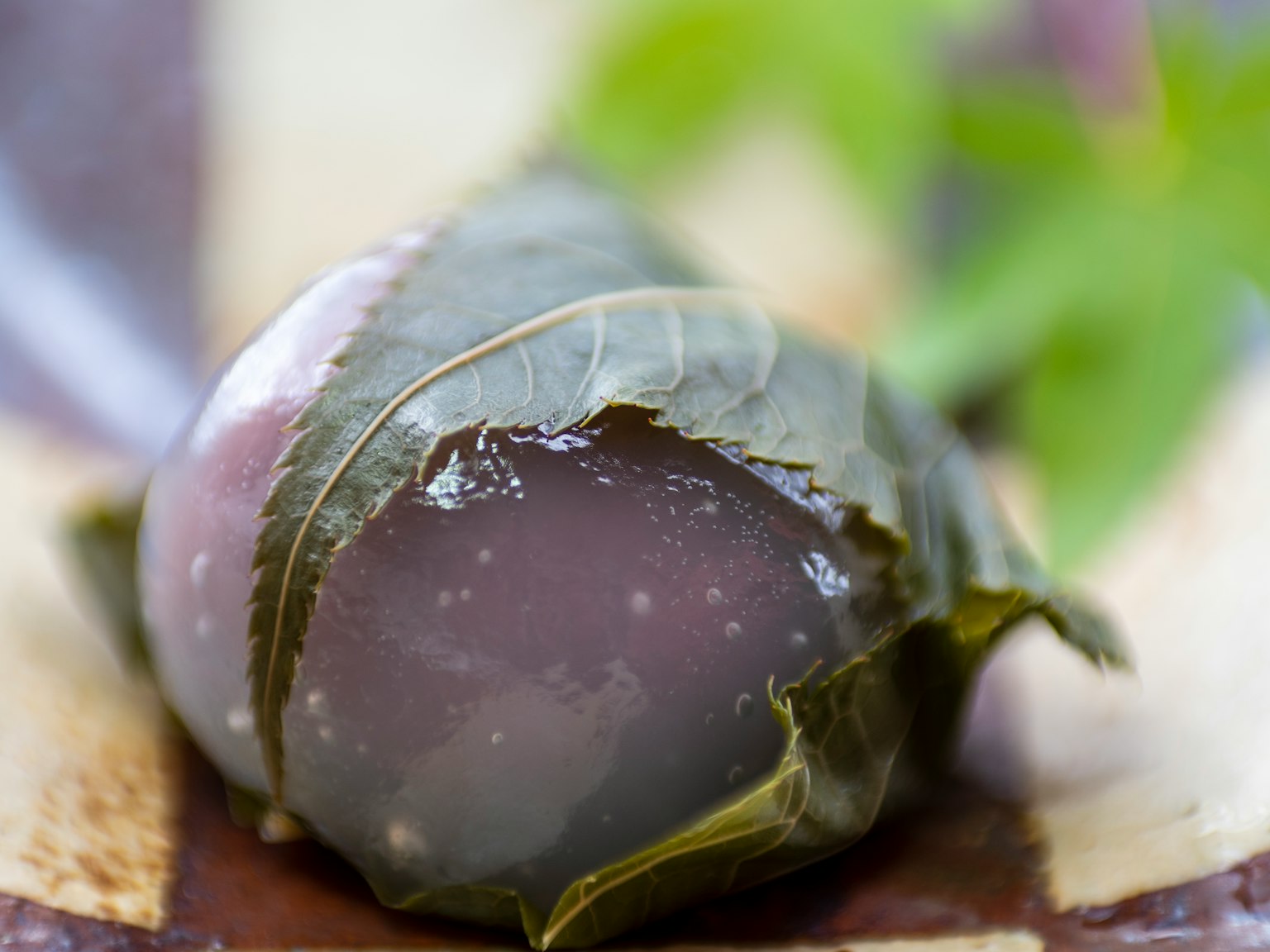 Primer plano de un tipo de confitería japonesa llamada daifuku envuelta en una hoja