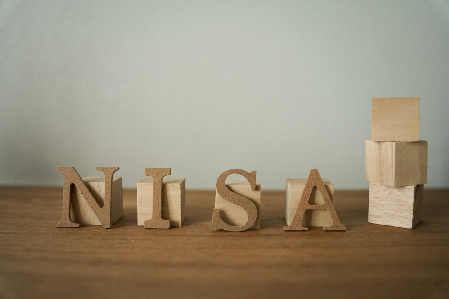 Image featuring wooden letters spelling out 'NISA' on a wooden surface