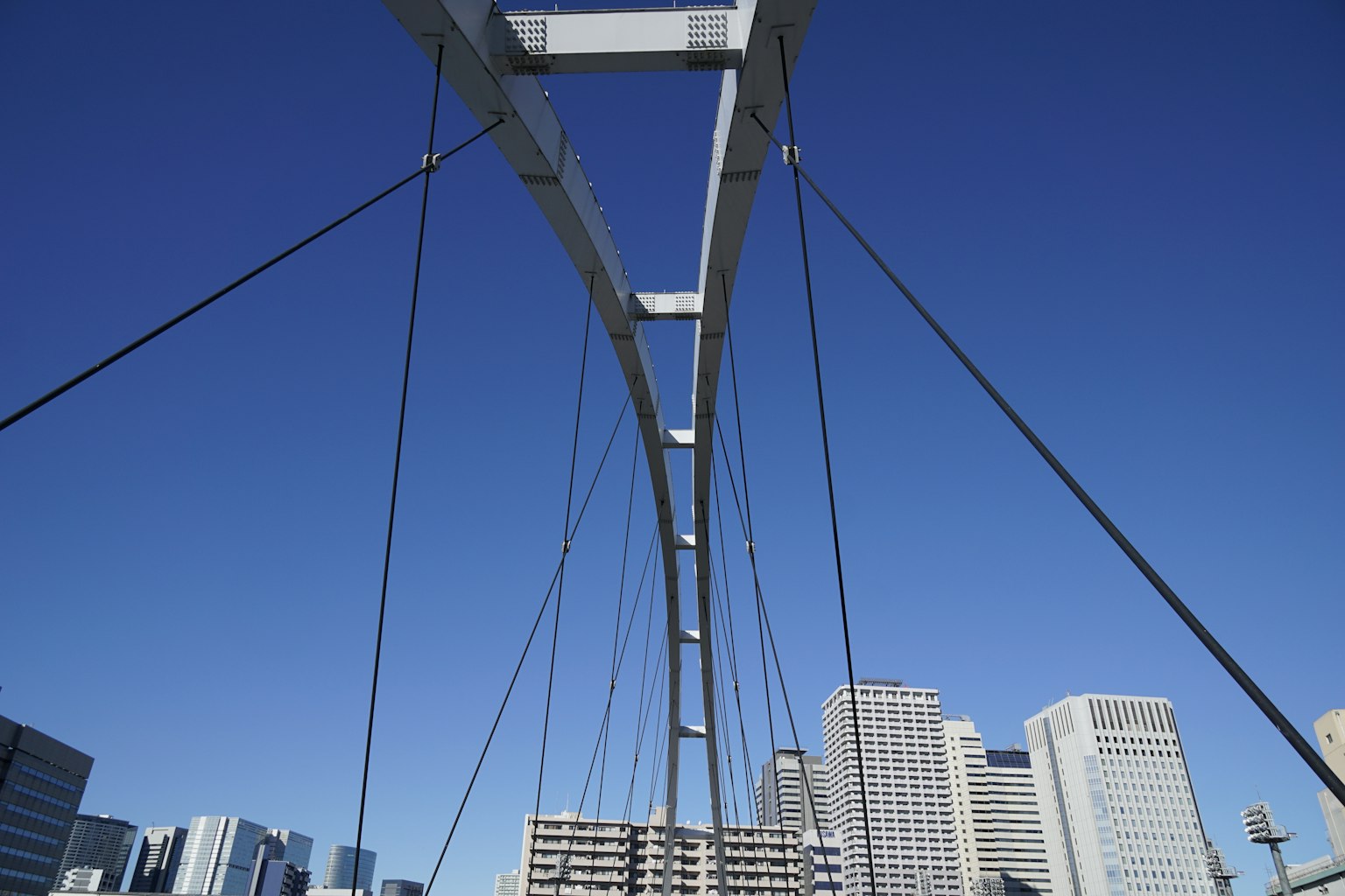 Structure de pont suspendu sous un ciel bleu avec des gratte-ciels environnants