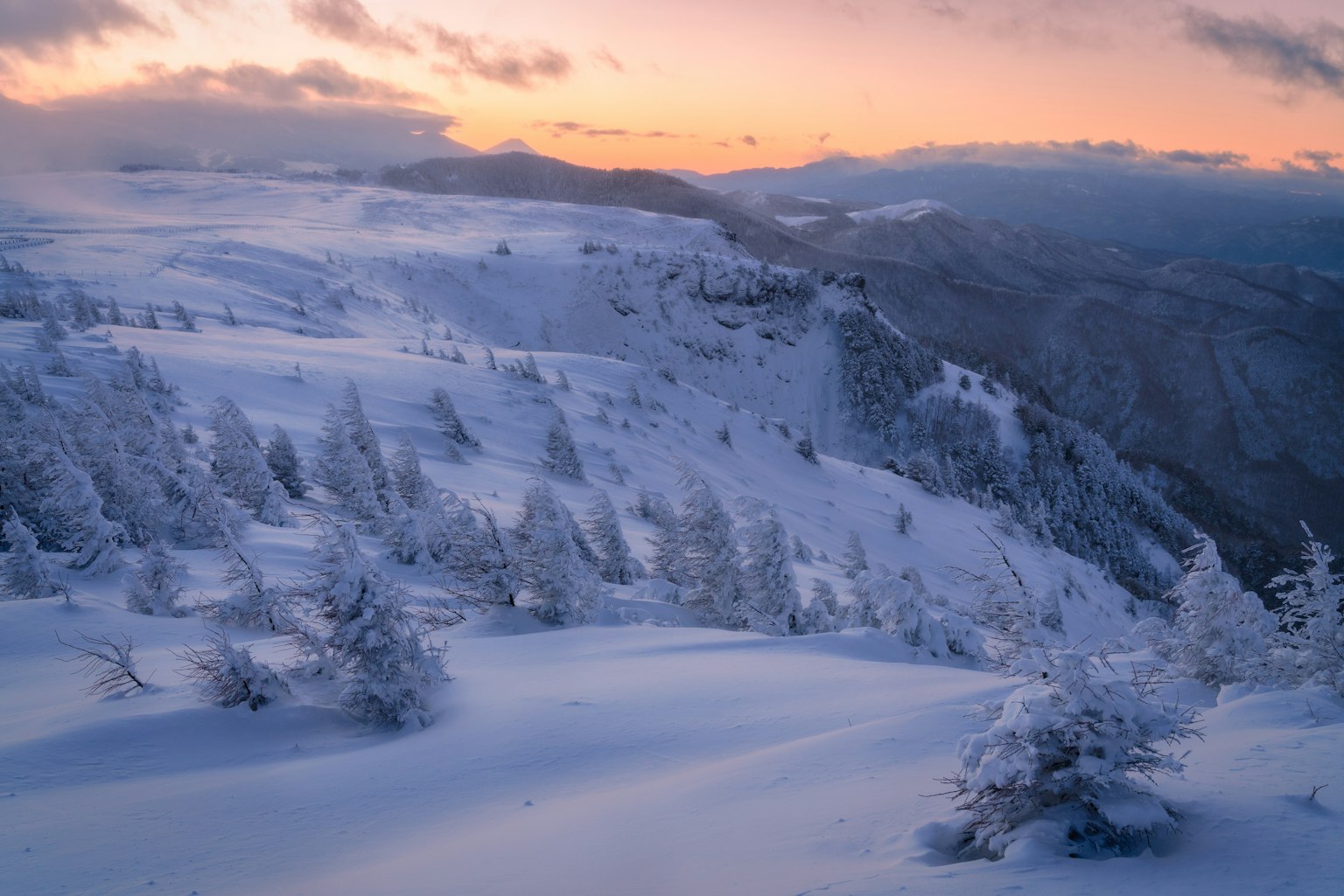 Schneebedeckte Berglandschaft mit Sonnenuntergangshimmel
