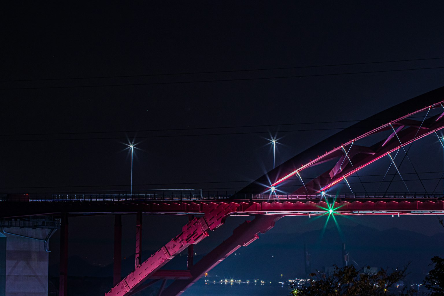 Night view of a red arch bridge with bright lights